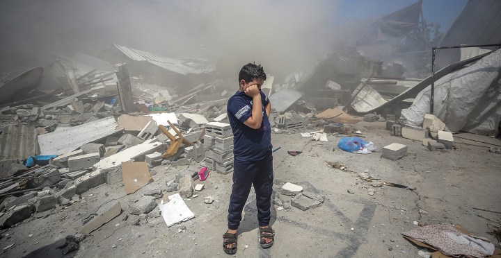 A Palestinian boy stands on the rubble of his destroyed house after an Israeli strike in Gaza City, 14 May 2021. (Photo: EPA-EFE/MOHAMMED SABER)
