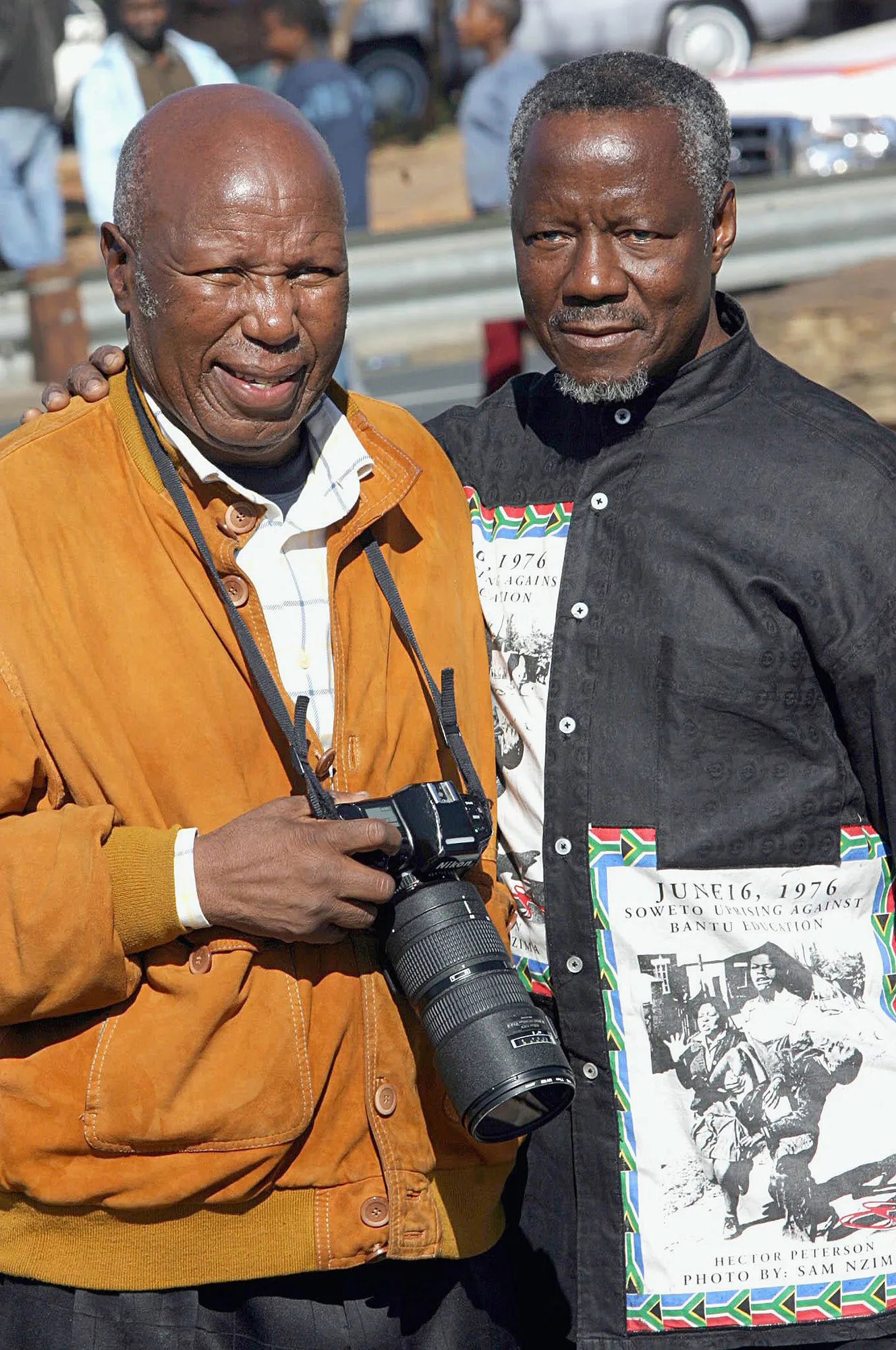 Alf Kumalo and Sam Nzima, wearing a shirt with his iconic Hector Pieterson image printed on his shirt.