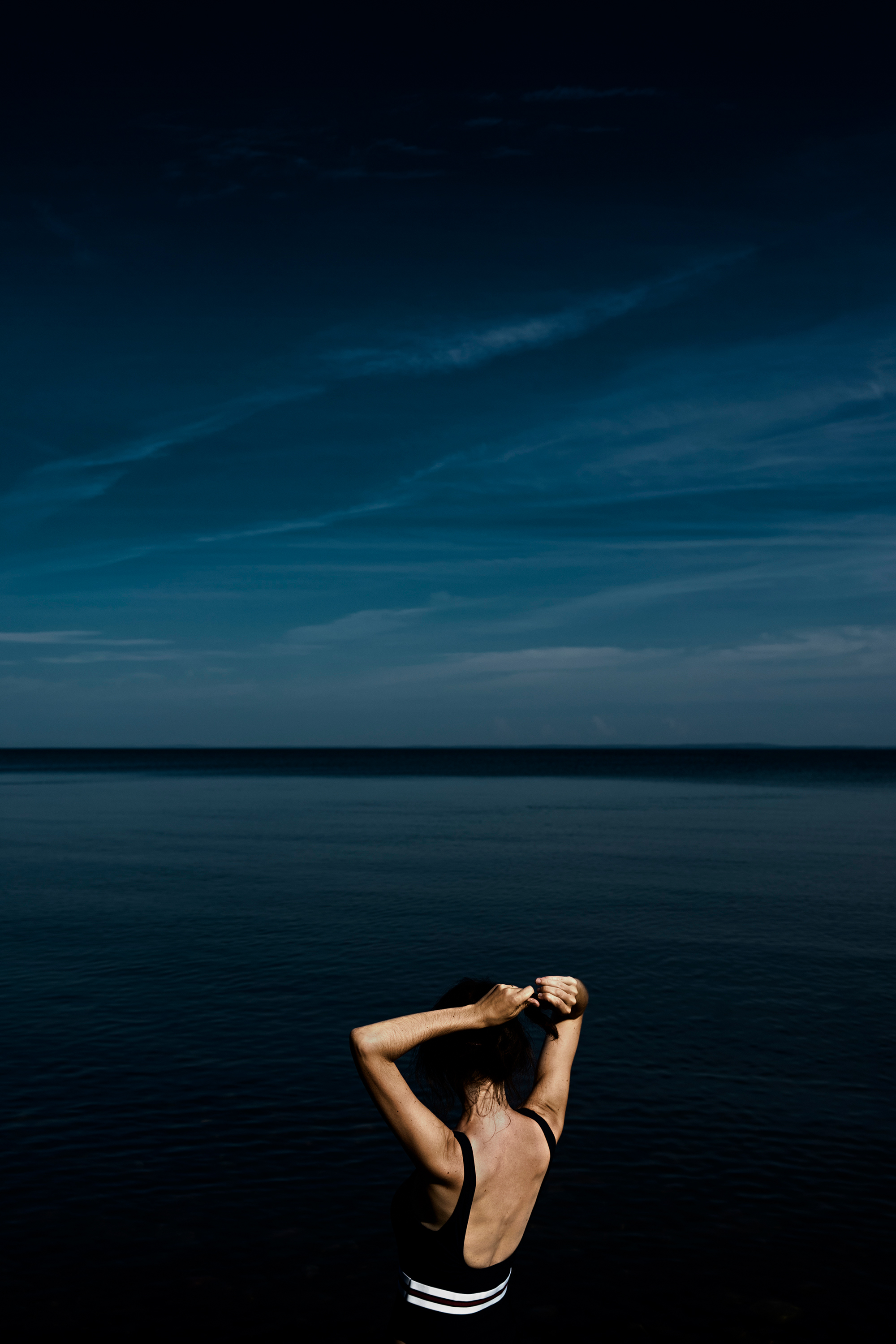 A women gets ready to swim in the waters of Bay of Fundy in Blomidon, Nova Scotia, Canada.