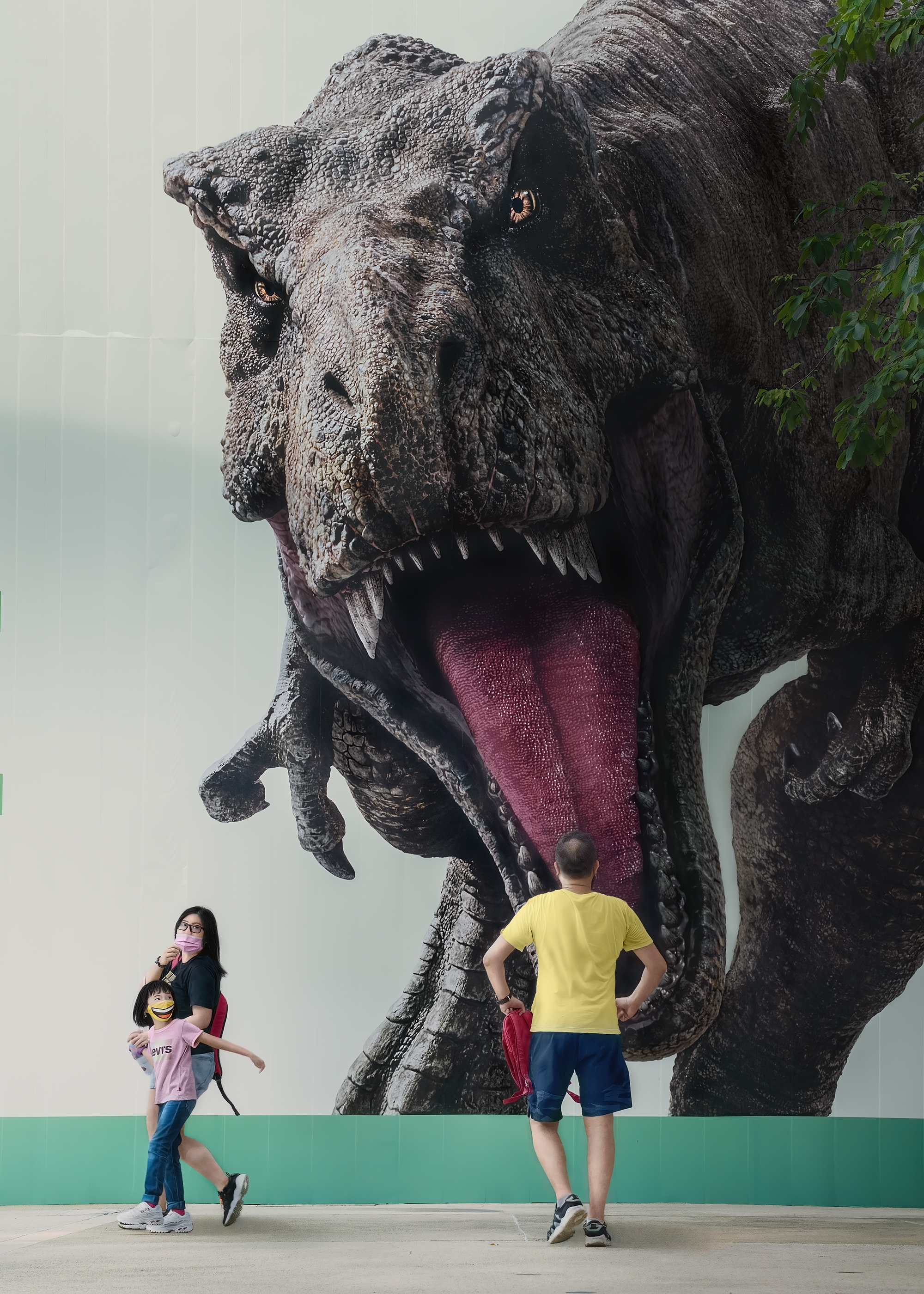 A man stares at a life-sized photo of a T-Rex. 