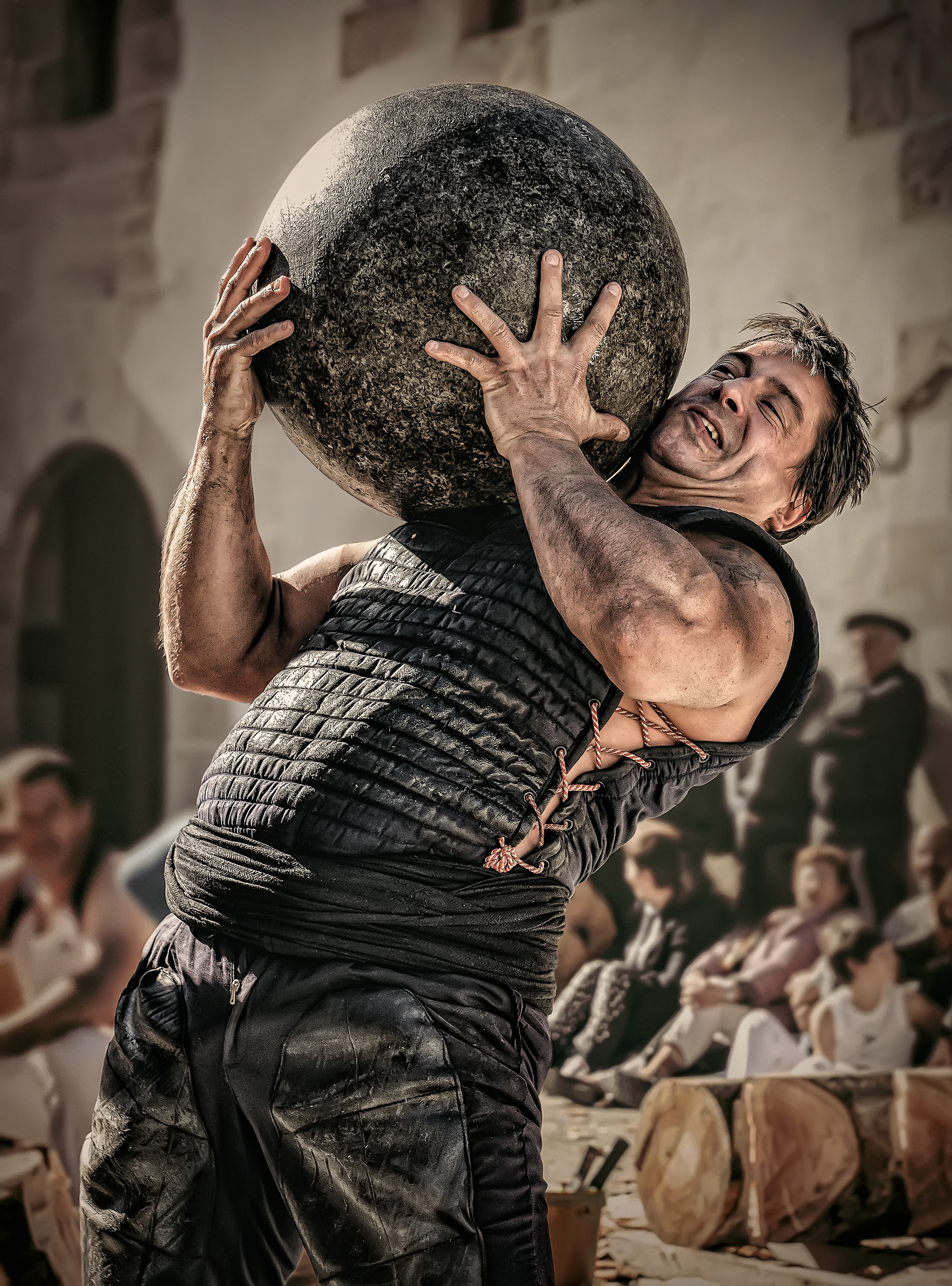A traditional basque sportsman lifting a round stone.