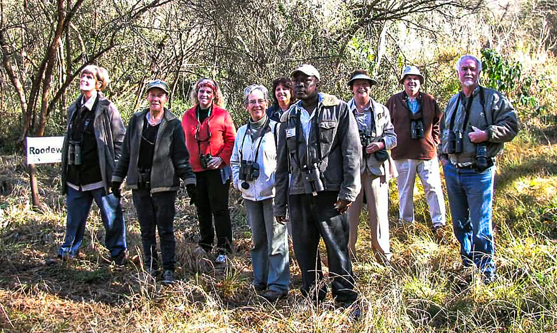 Bird guide Samson Mulaudzi exploring a wooded area with guests