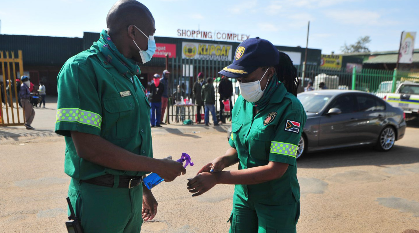 EMS workers apply hand sanitiser