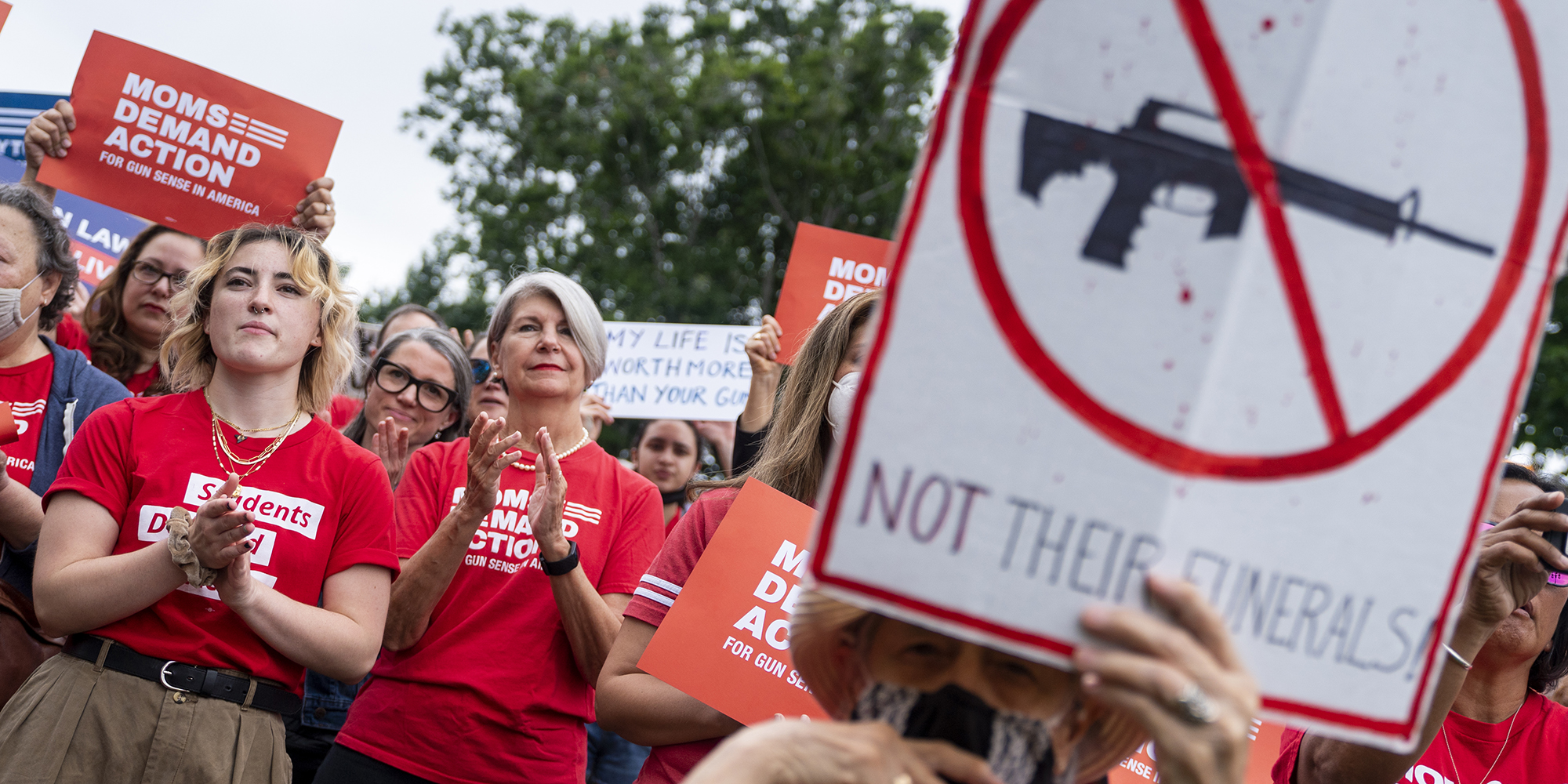 Anti-gun activists protest with signs and insignia against firearms outside the White House in Washington