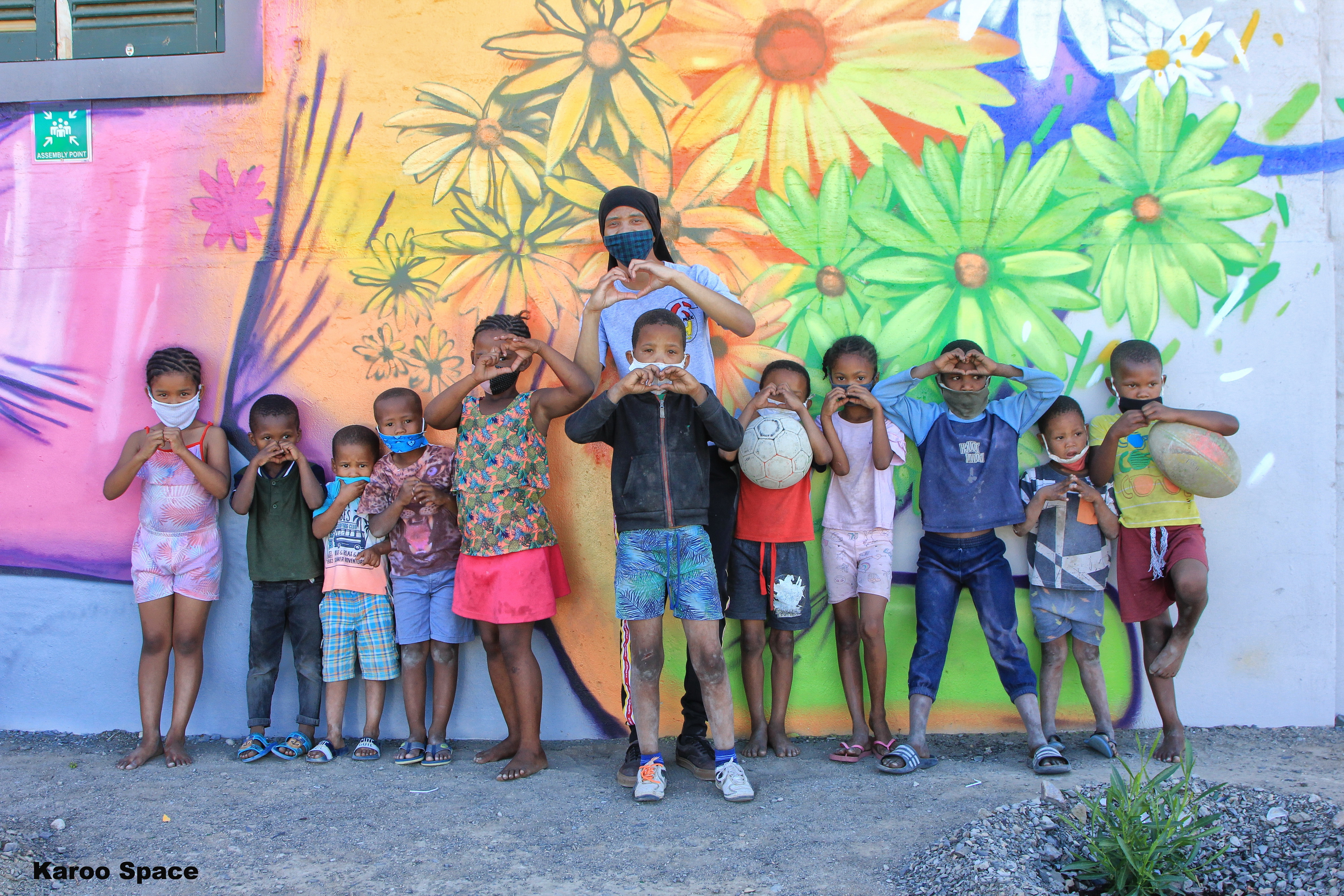 Prince Albert kids in front of a Falko One mural.