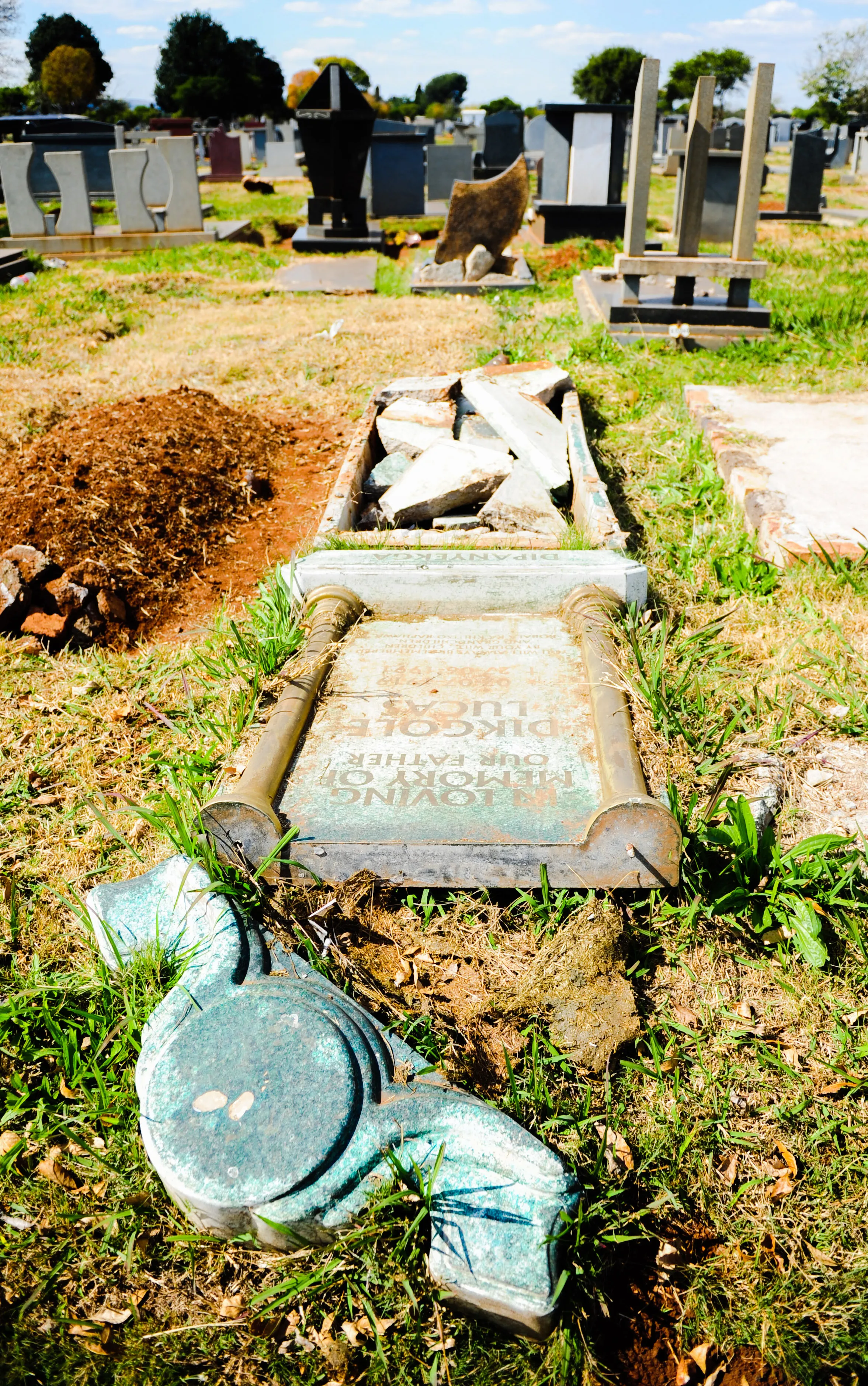 Broken graves lie strewn on the ground at Avalon cemetery