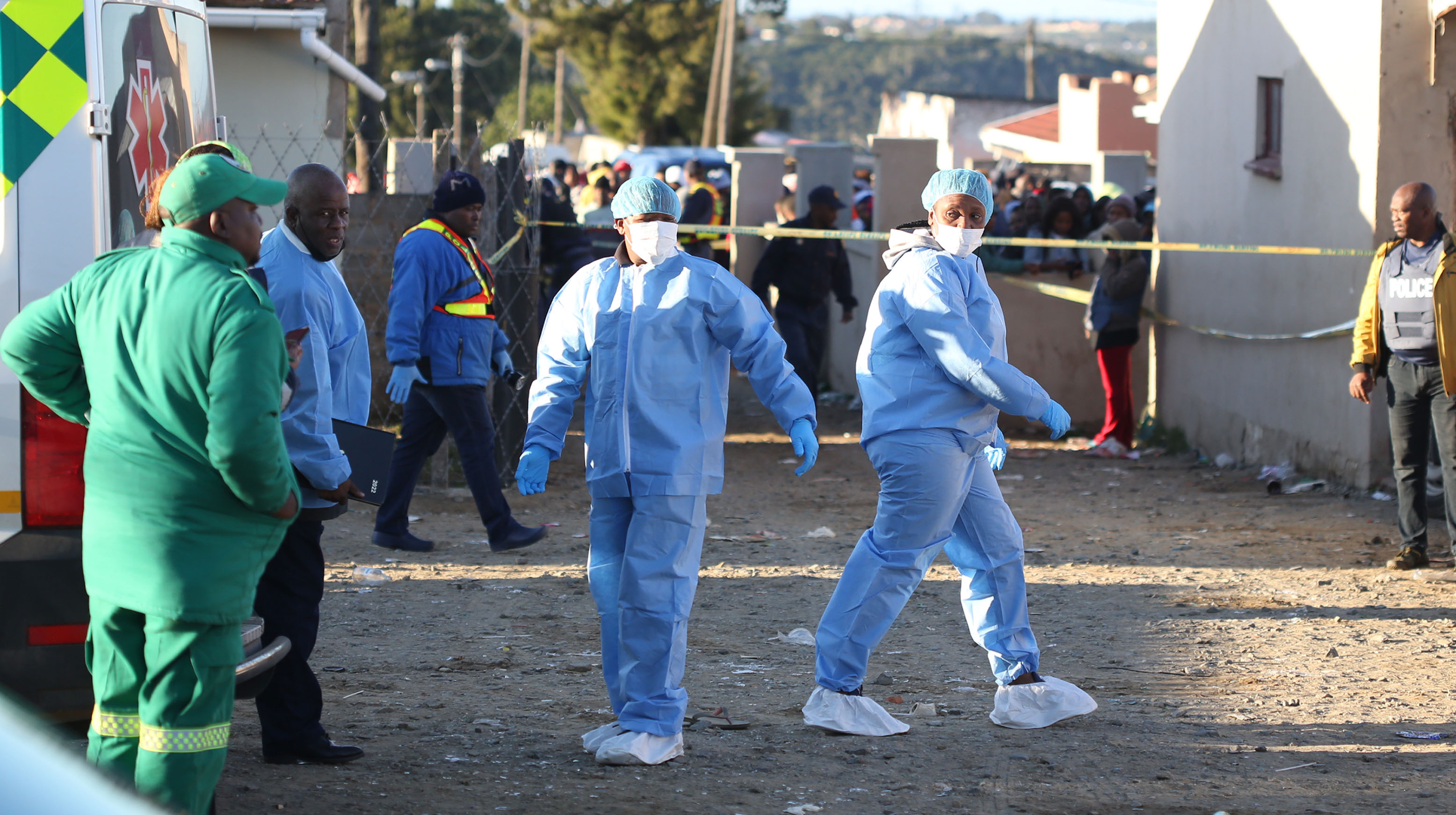 Pathologists work at the Eastern Cape tavern where 21 people were found dead.