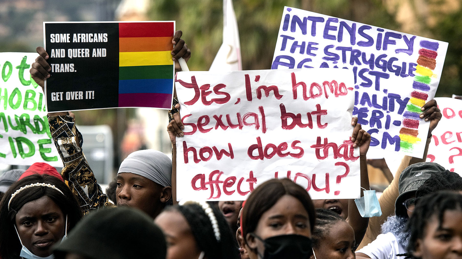 LGBTQI+ protesters hold signs as they march towards Parliament in Cape Town.