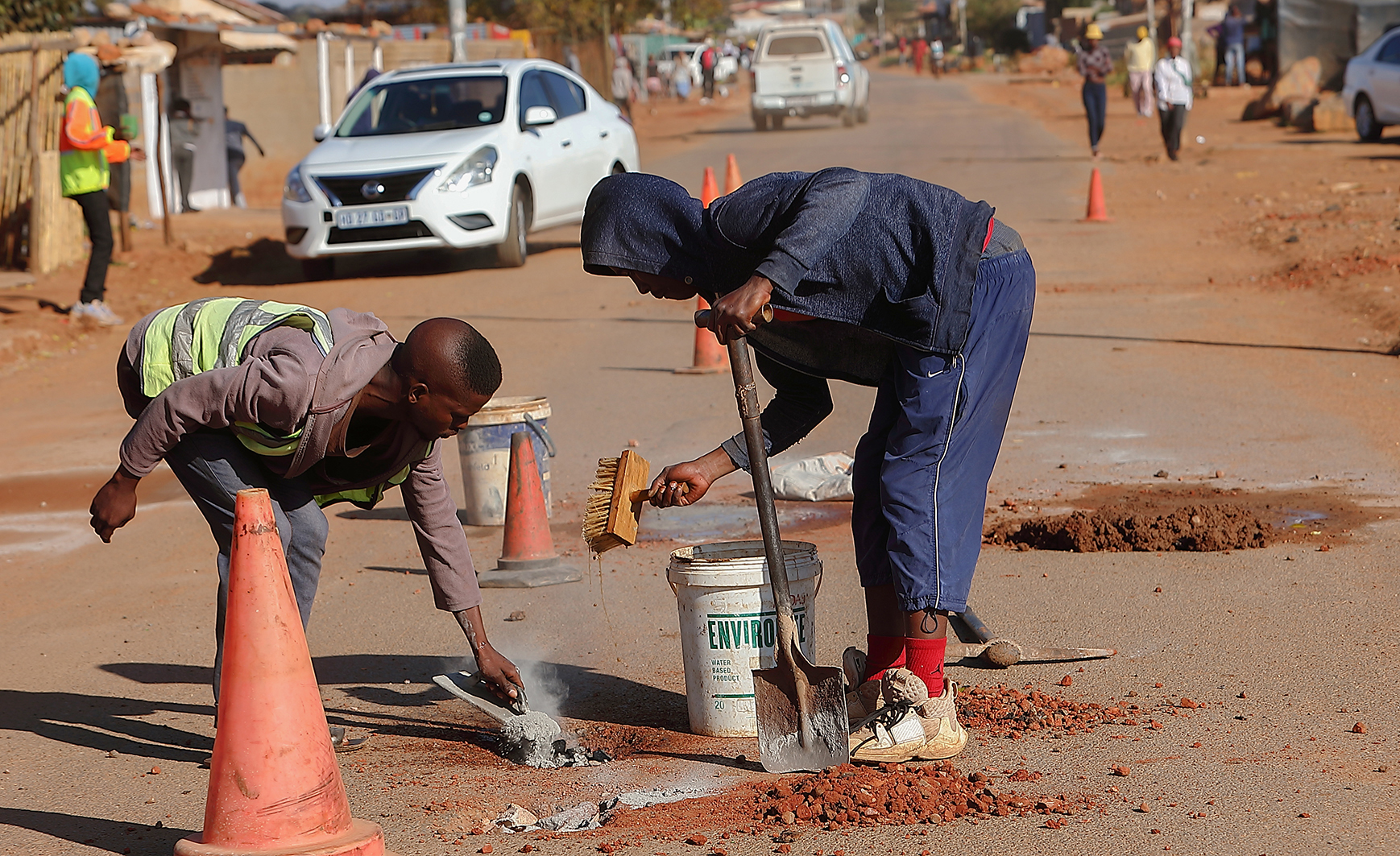 An image of unemployed volunteers fixing potholes