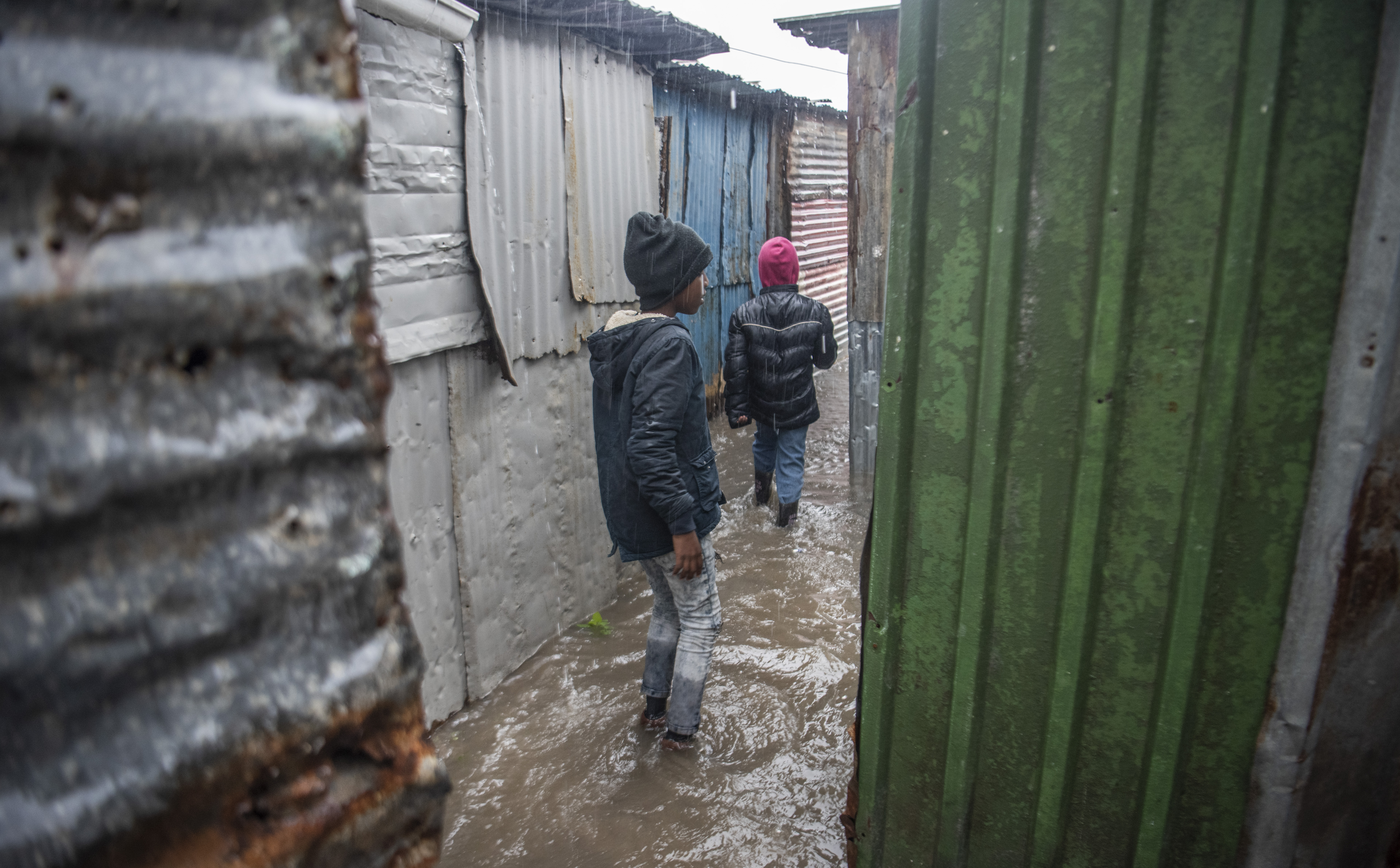 Children walk in the floods between houses in Khayelitsha Site B