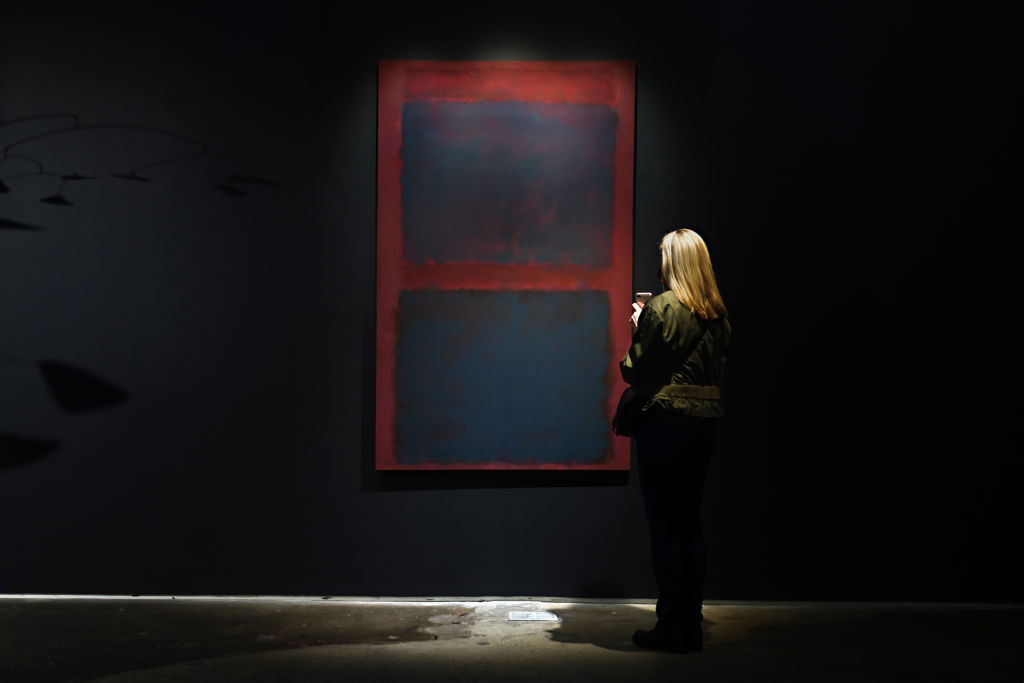 A person looks at "Untitled (Black on Maroon)" by Mark Rothko.