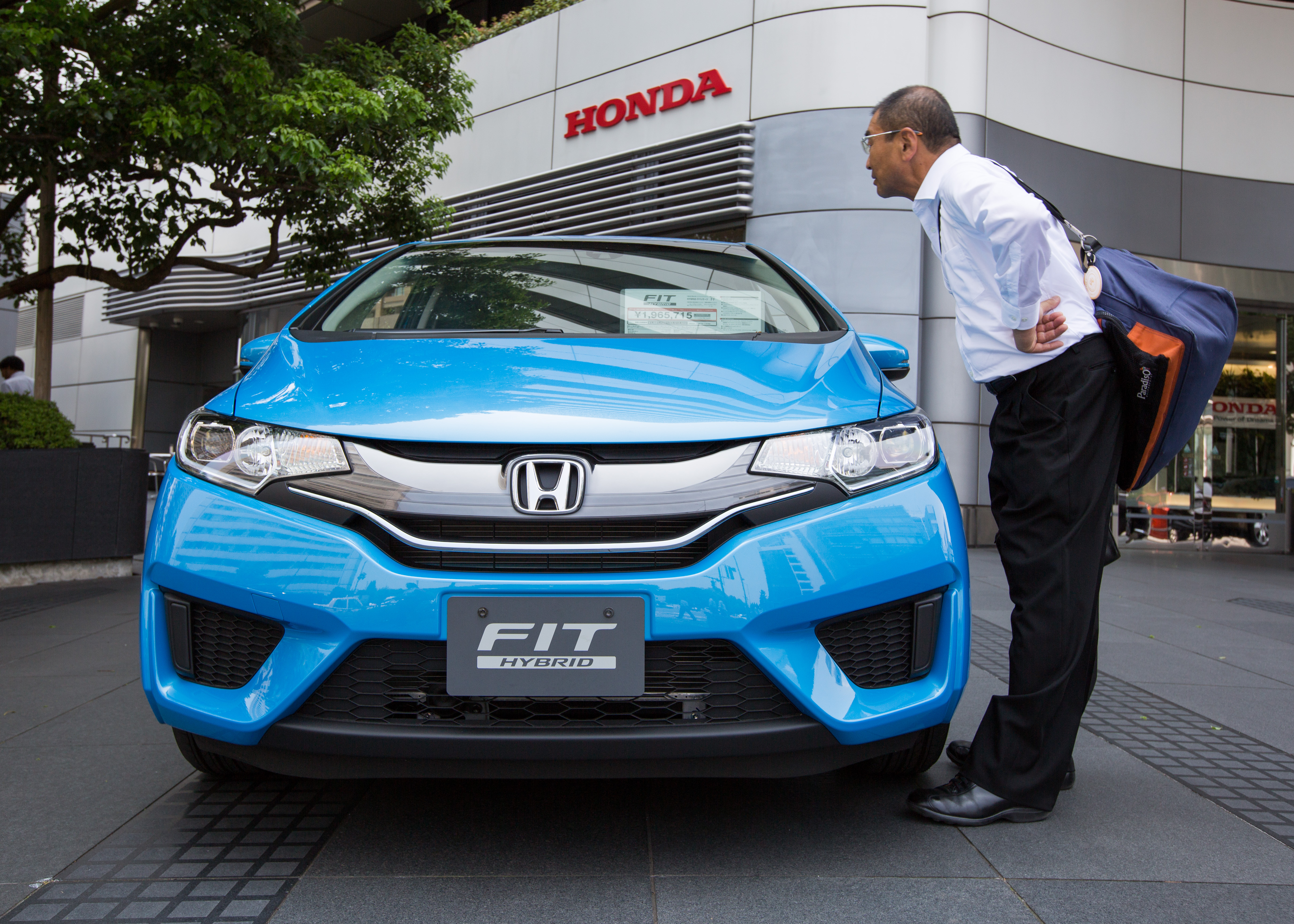 A businessman views a Honda Fit Hybrid vehicle displayed outside the car maker headquarters' showroom in Tokyo, Japan, 31 July 2015. 
