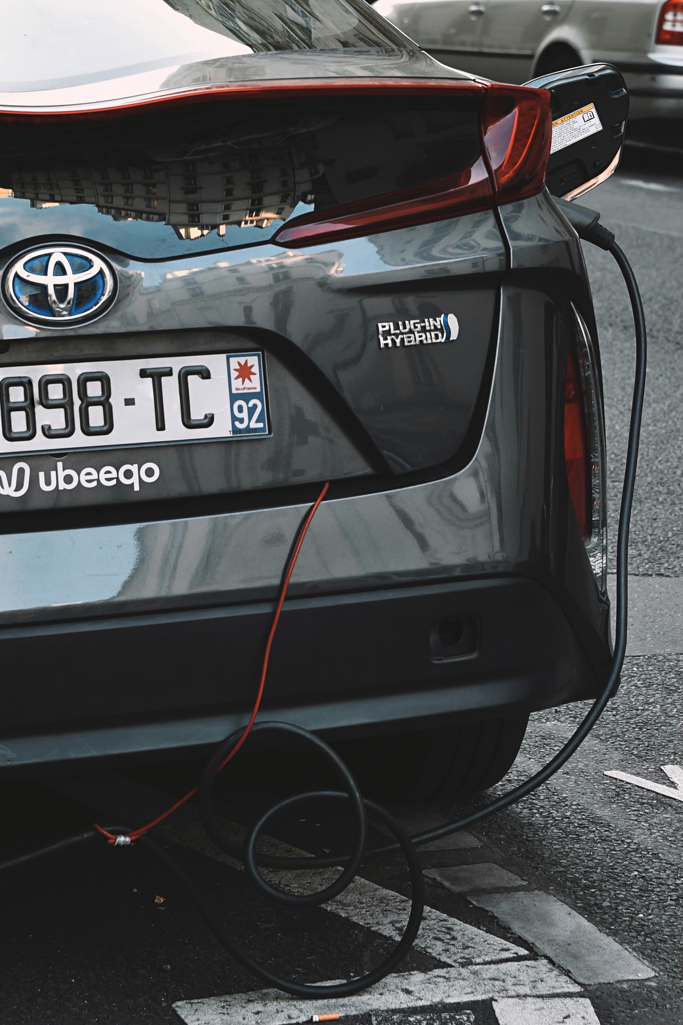 A Toyota plug-in hybrid is seen charging outdoors. 