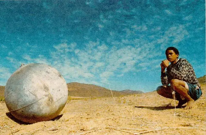 Theodore Solomons sits next to the metal ball that he saw fall from the sky on a farm close to Worcester, about 150 kilometres outside of Cape Town, south Africa in April 2000. A second metal ball dropped out of the sky the following day on a farm approximately 50 kilometres outside of Cape Town. Astronomers said the balls, which were white-hot when they landed, could be parts of a decaying satellite.