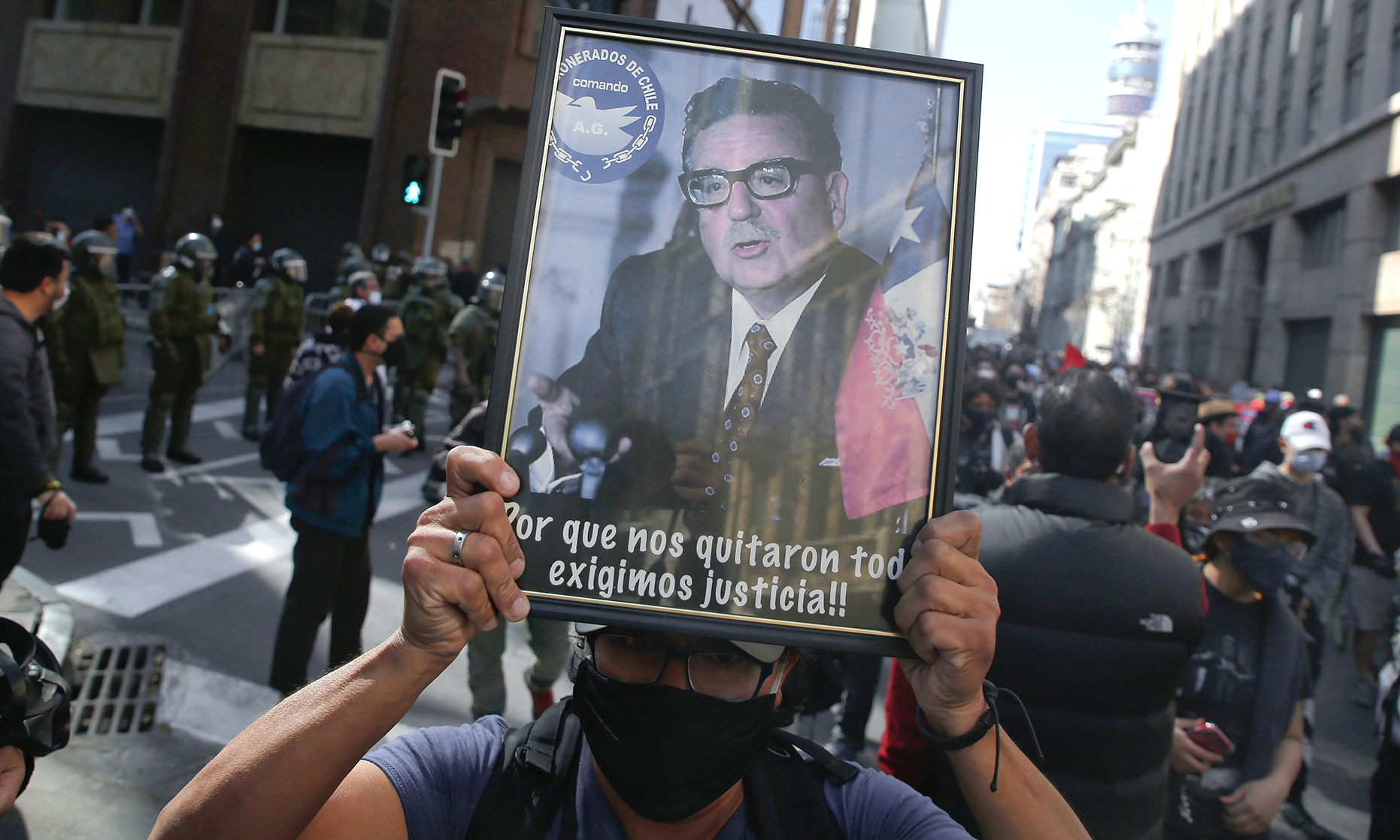 A demonstrator holds a photo of former president Salvador Allende in Chile