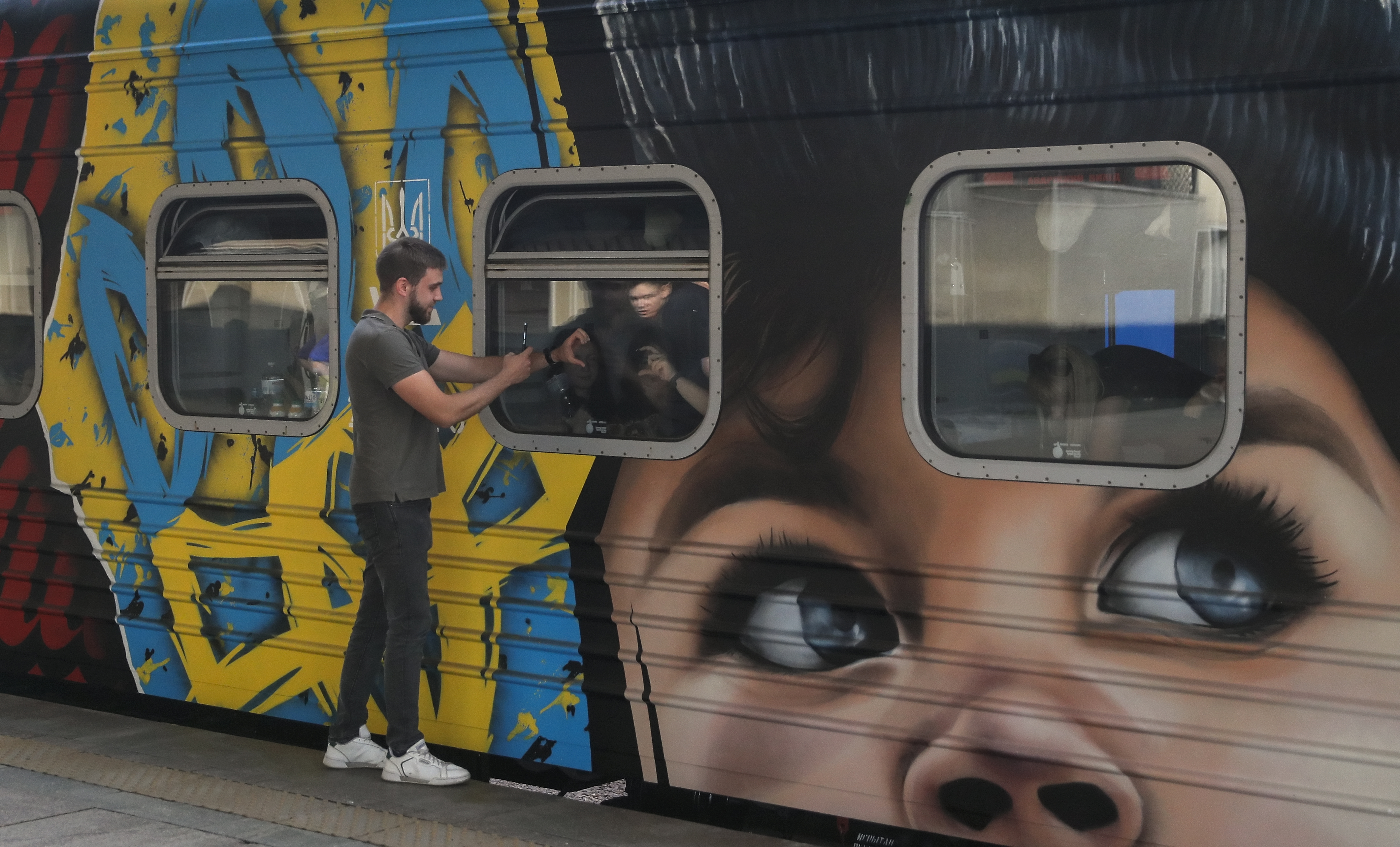 Ukrainians say goodbye to the passengers of the train named The Train to Victory' at the railway station in Kyiv, Ukraine, 23 August 2022. The Train to Victory project consists of seven train cars painted by Ukrainian artists. Each car is dedicated to the temporarily occupied territories of Ukraine and the feats of Ukrainians resisting Russian invasion. The Train to Victory left Kyiv for its first trip and will arrive in the Western Ukrainian city of Uzhgorod on Independence Day on 24 August. EPA-EFE/SERGEY DOLZHENKO