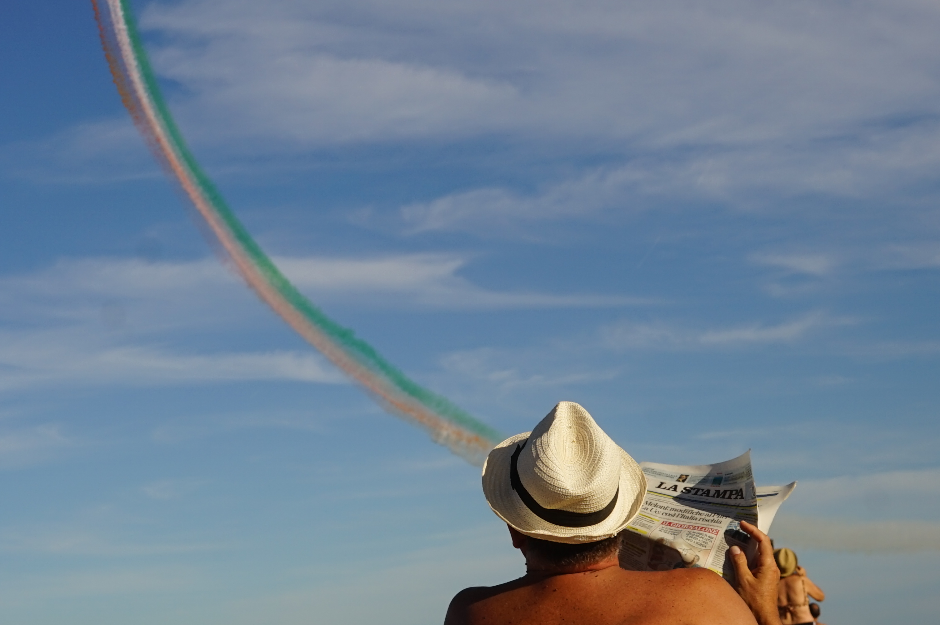 Italian newspaper. "The Italian tricolor arrows perform in the sky above the city of Portorecanati but on the beach there is a gentleman who is more interested in reading the newspaper. © Maurizio Ghiandoni, Italy, entry, Open Competition, Creative, 2023 Sony World Photography Awards
