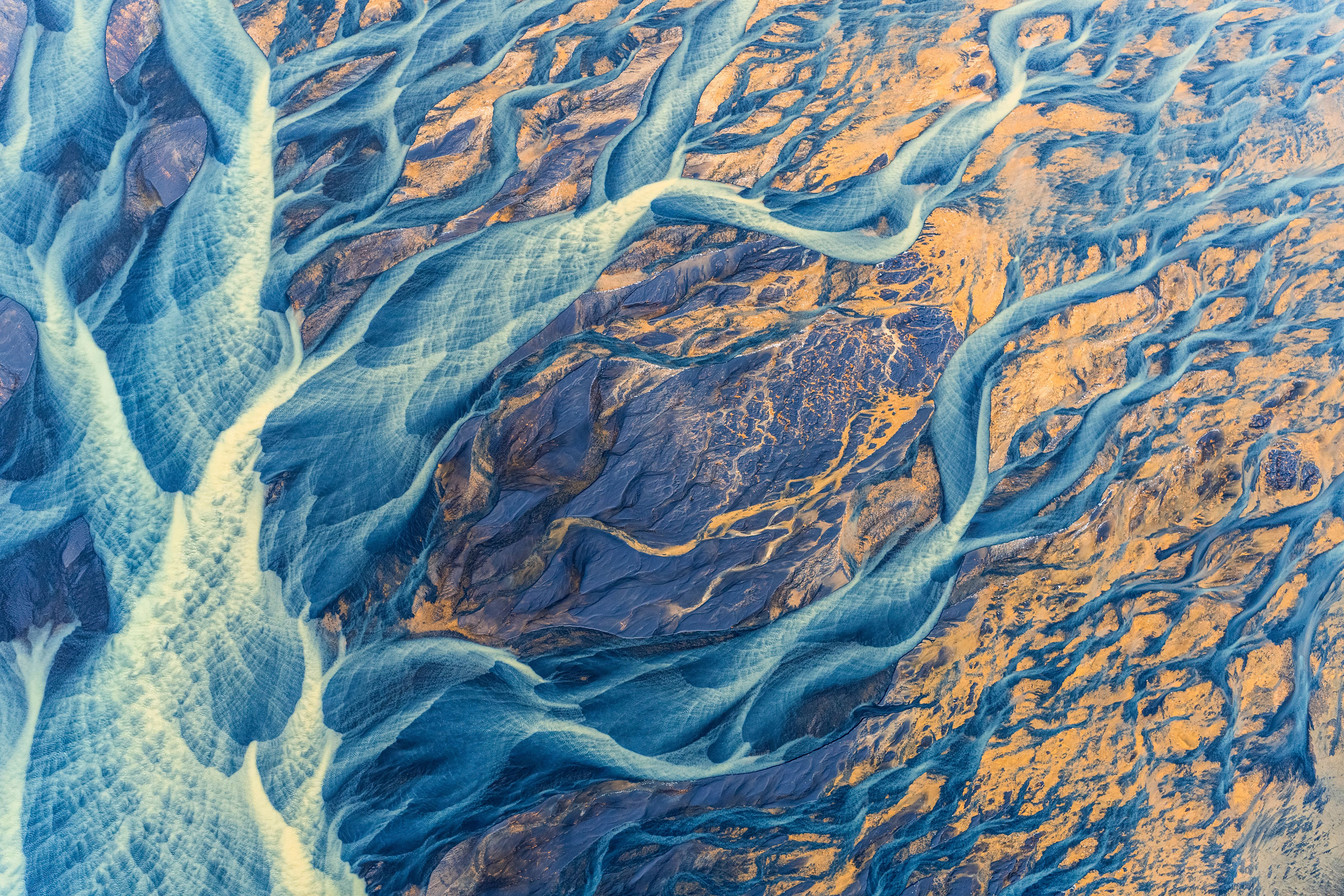 'Braided River'. Brightly colored sediment paints the Icelandic landscape as at flows towards the ocean. The glacial river, Þjórsá, is the longest river in Iceland, originating at Hofsjökull glacier and meandering 230km to the Atlantic Ocean. The aerial perspective provided by a small airplane, reveals the bright and varied colored sediment tracing the river's path towards the ocean. © Kristin Wright/TNC Photo Contest