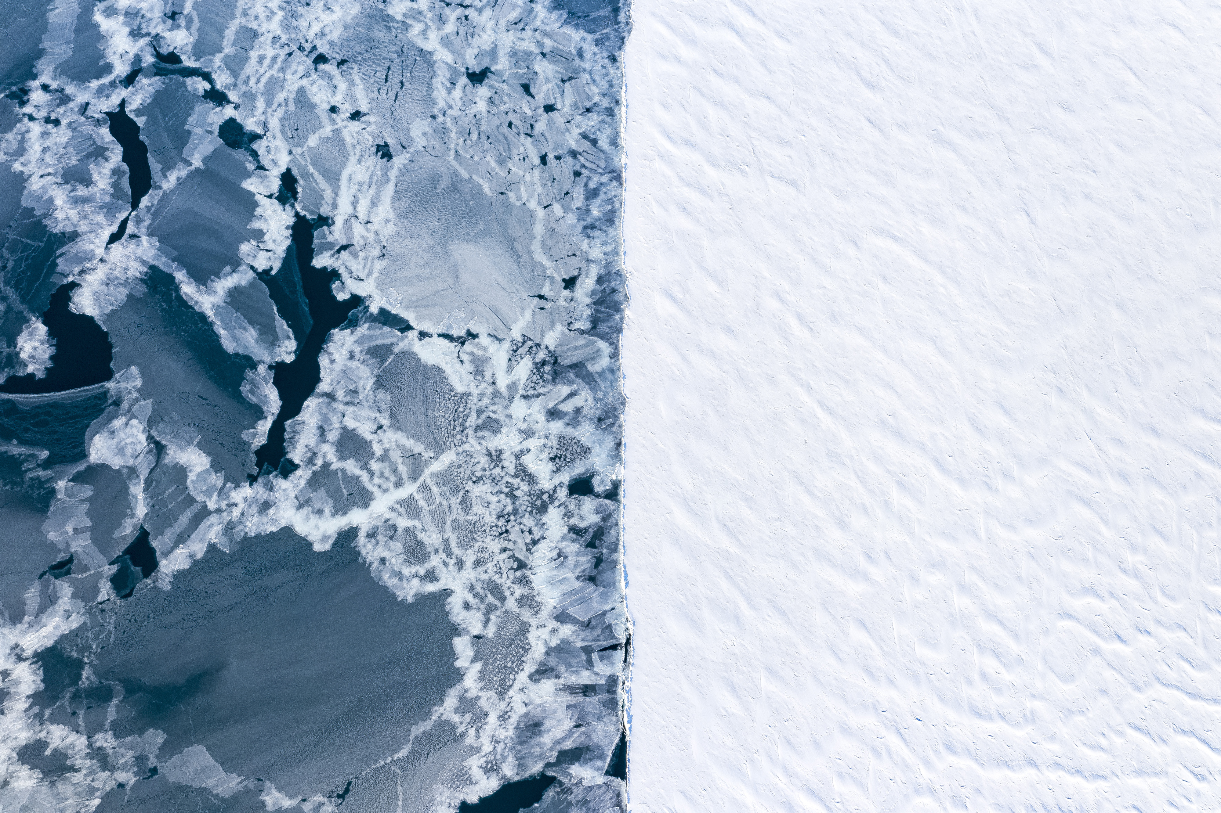 'Two world'. Aerial view of two different type of ice in winter. On the right side, the well established fast ice, a solid environment for the bears, on the left, the open water refreezing after a storm took away the ice. Sea ice being less thick than it used to be it is being more affected by the seasonal winter storm, easily breaking apart. © Florian Ledoux/TNC Photo Contest