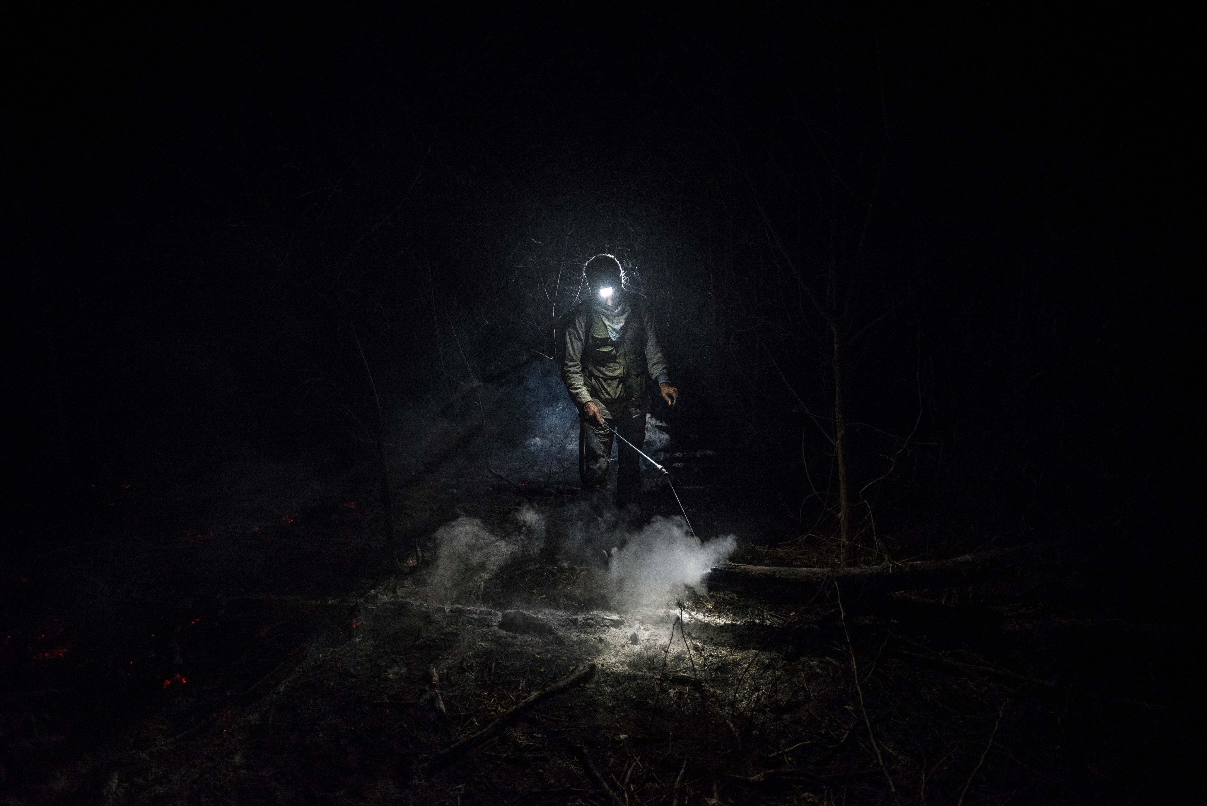 'The Tucabaca’s night'. Volunteer forest firefighter Daniel Vargas Osinaga (21) walks through thick smoke after helping to extinguish a fire in Santa Rosa de Tucabaca, a conservation valley of La Chiquitania dry forests, Southeastern Bolivia, on August 25, 2019. For nearly three months, hundreds of firefighters and volunteers worked under extreme temperatures trying to put out the fires that burned more than 5.3 M hectares. © Marcelo Perez del Carpio/TNC Photo Contest