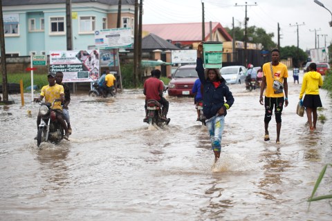 People wade through a flooded road after a rainfall in Lagos, Nigeria 12 September 2022. EPA-EFE/Akintunde Akinleye