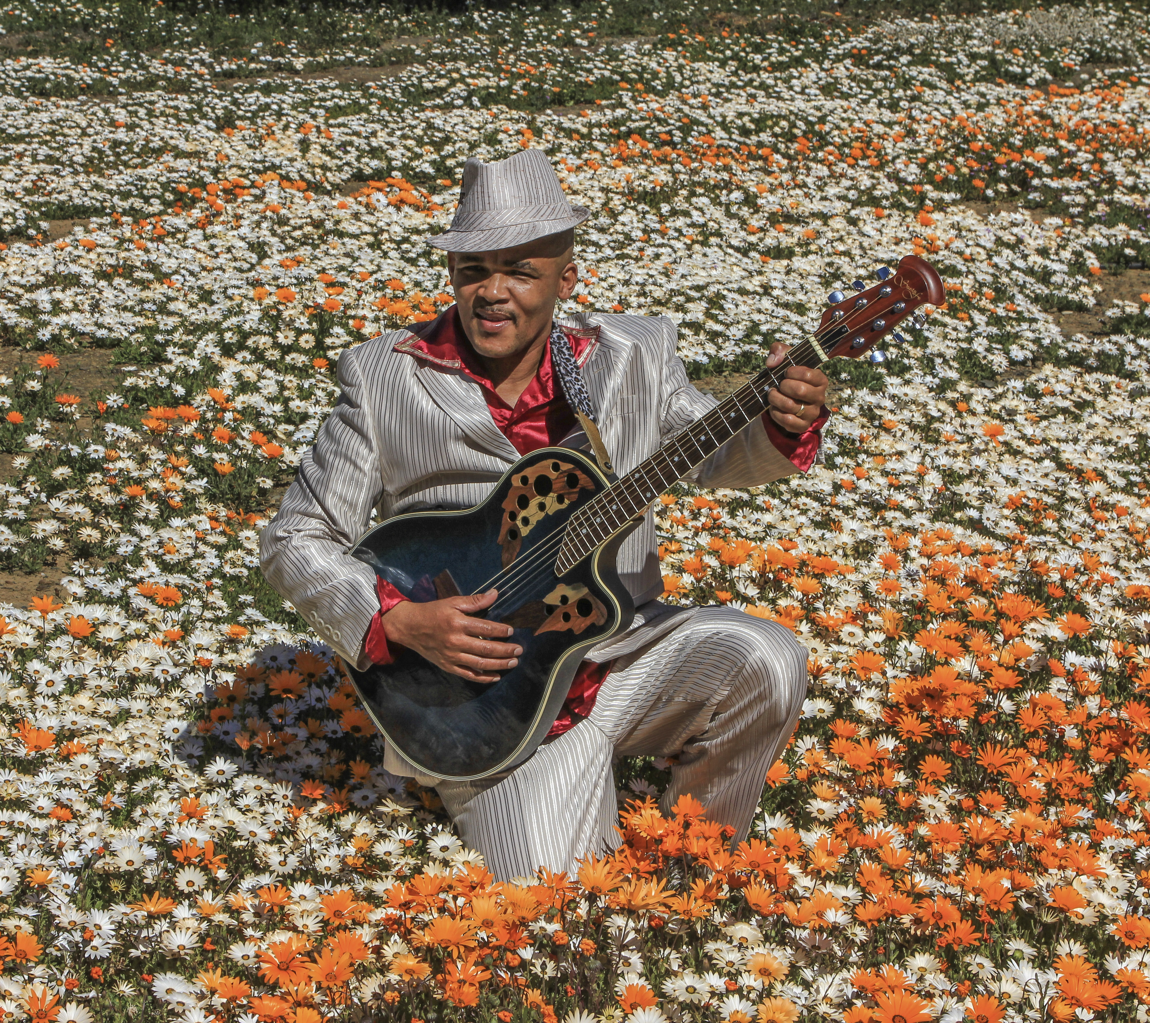 Boeta Gammie in his shiny suit, among Calvinia’s spring daisies.