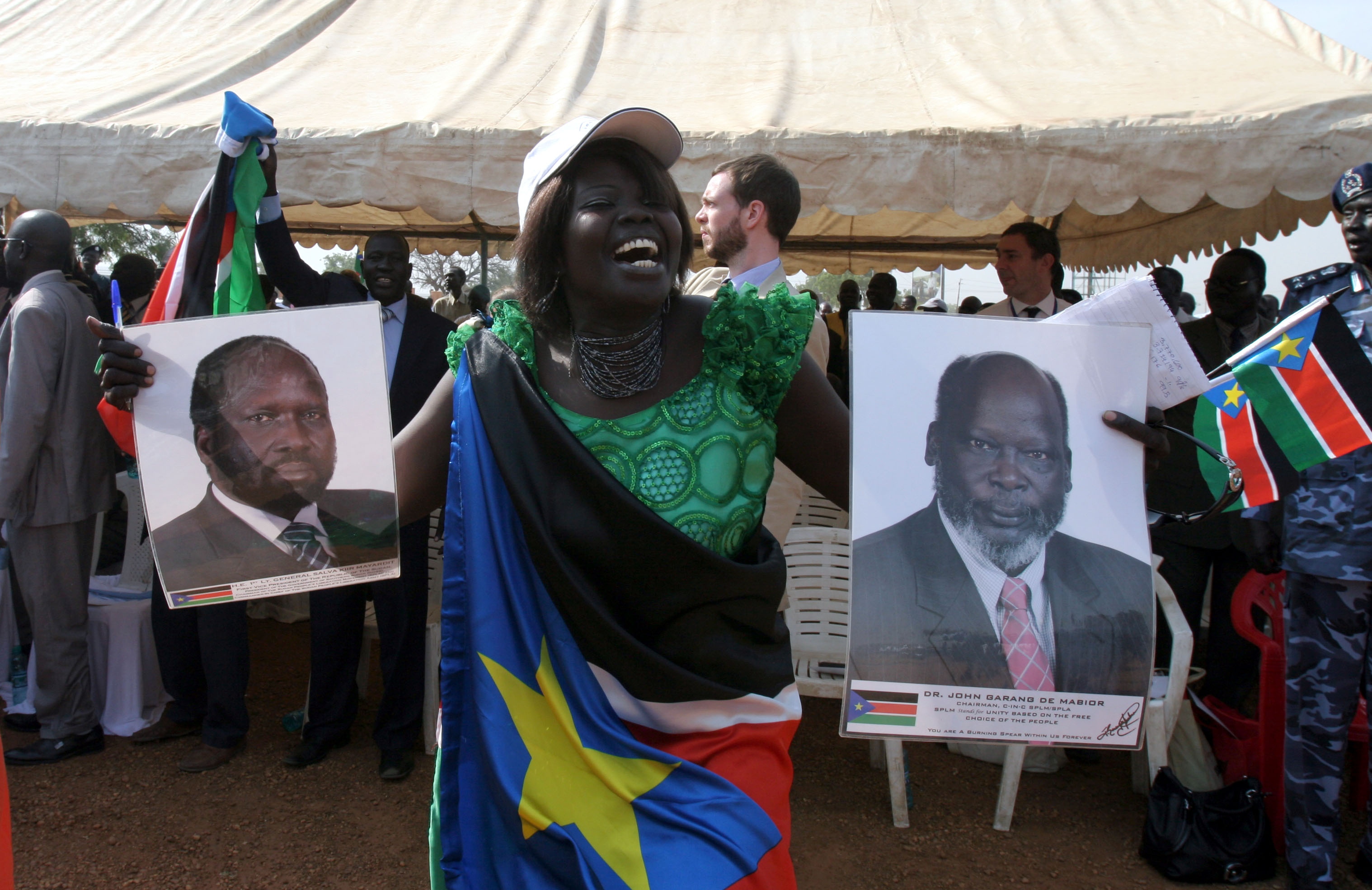 epa02556848 A South Sudanese woman holds pictures of late politican and rebel leader John Garang de Mabior (R) and of First Vice President of Sudan and President of the Government of Southern Sudan Salva Kiir Mayardit (L) celebrates in Juba 30 January 2011 after hearing the preliminary result of the recent independence referendum. Just short of 99 per cent of Southern Sudanese have voted to secede from the north and form an independent state, according to preliminary results released 30 January. EPA/PHILIP DHIL