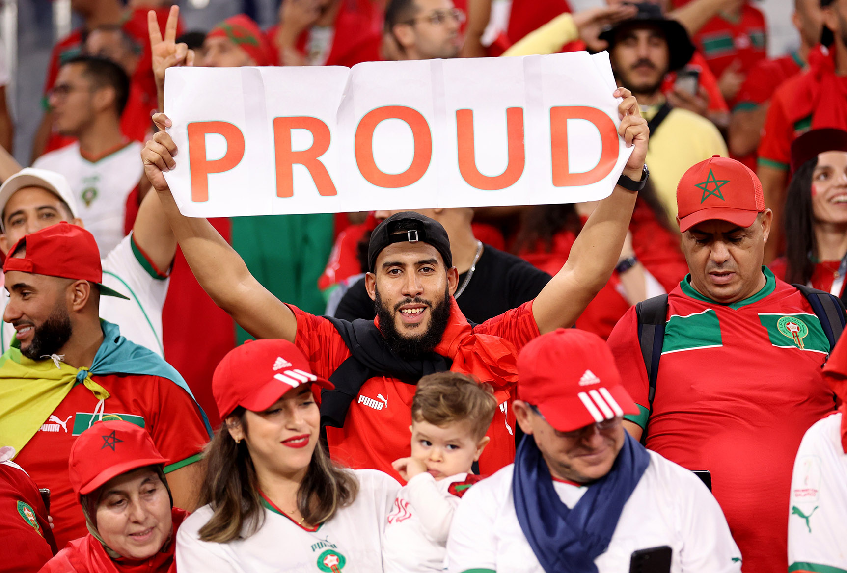 A fan of Morocco with a sign saying "proud" 