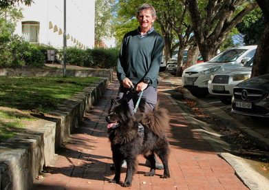 Professor Justin Jonas in 2022, standing where “inter-networking” in South Africa began, between the Struben Computing Centre and the Physics Department at Rhodes University, with dog Koda. Image: Chris Marais