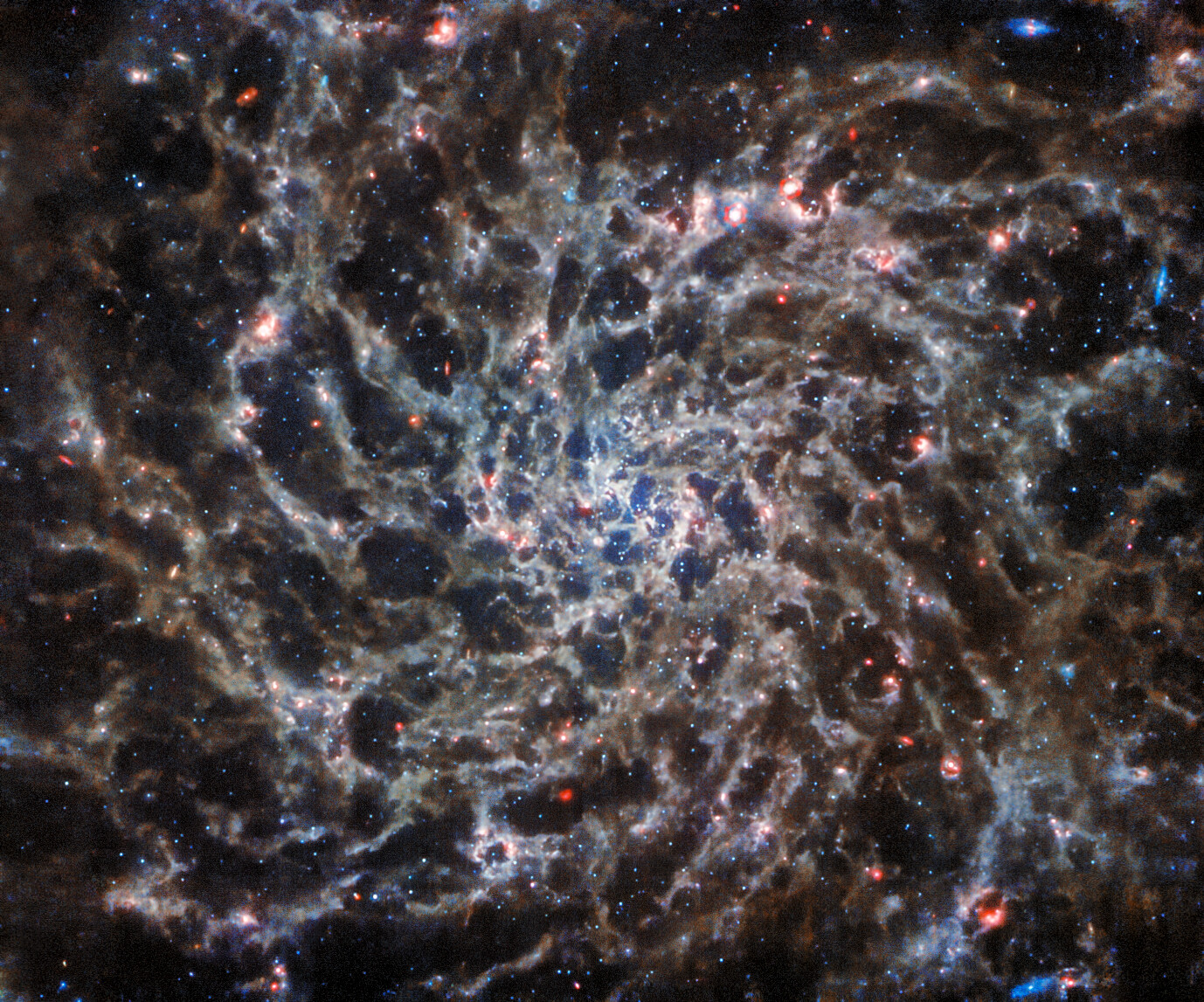 This image from the NASA/ESA/CSA James Webb Space Telescope shows IC 5332, a spiral galaxy, in unprecedented detail thanks to observations from the Mid-InfraRed Instrument (MIRI). Its symmetrical spiral arms, which appear so clearly in Hubble’s ultraviolet and visible-light image of IC 5332, are revealed as a complex web of gas, emitting infrared light at a variety of temperatures. Capturing light at these wavelengths requires very specialised instruments kept at very cold temperatures, and MIRI performs spectacularly at the task. Image: ESA/Webb, NASA & CSA, J. Lee and the PHANGS-JWST and PHANGS-HST Teams