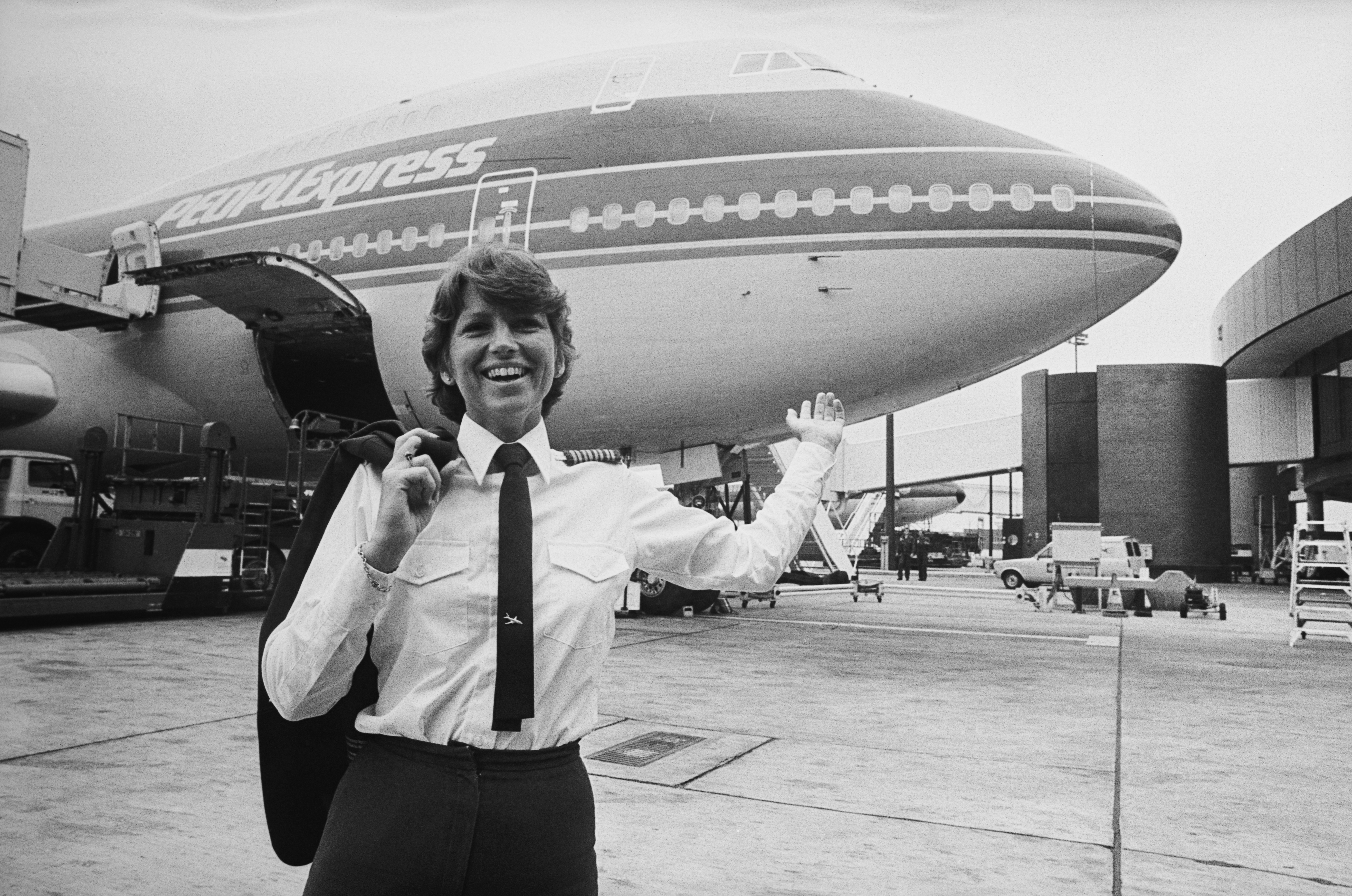 American pilot Captain Lynn Rippelmeyer, the first woman to captain a Boeing 747 across the Atlantic Ocean, stands before a PEOPLExpress aircraft, 20th July 1984. Image: P. Shirley / Daily Express / Hulton Archive / Getty Images