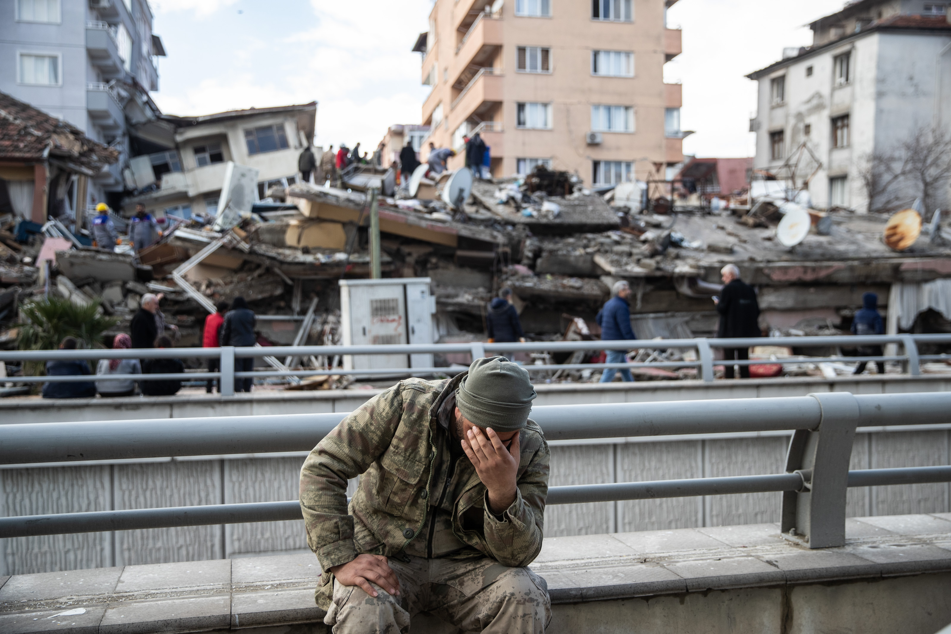 HATAY, TURKEY - FEBRUARY 07: A soldier sits devastated near the collapsed building on February 07, 2023 in Hatay, Turkey. A 7.8-magnitude earthquake hit near Gaziantep, Turkey, in the early hours of Monday, followed by another 7.5-magnitude tremor just after midday. The quakes caused widespread destruction in southern Turkey and northern Syria and were felt in nearby countries. (Photo by Burak Kara/Getty Images)