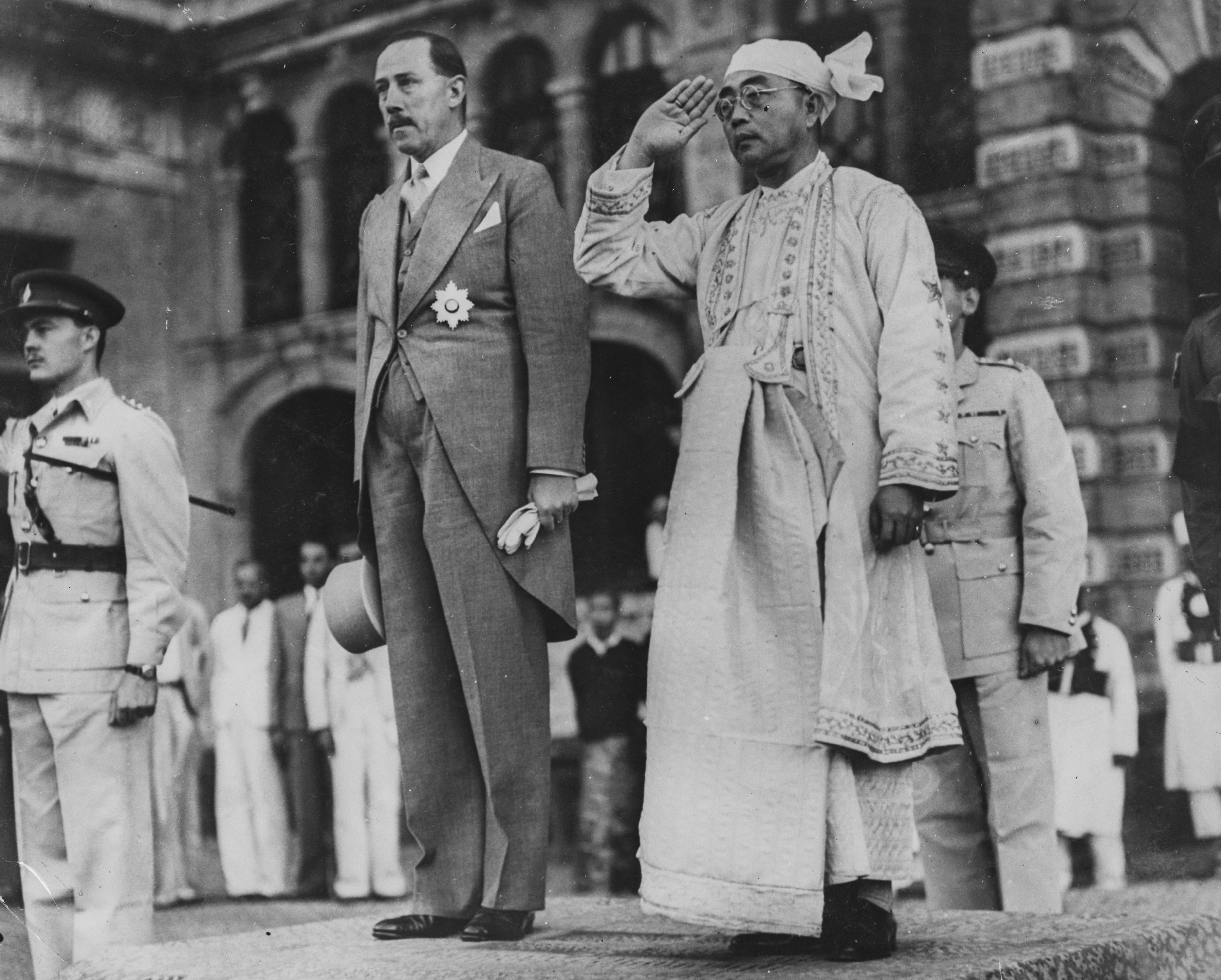 The President of Burma Sao Shwe Thaik (right) saluting as he and Governor Sir Rupert Rance watch a march past of the Guard of Honor, celebrating the inauguration of the Independence of Burma in Rangoon, January 13th 1948. Today, Rangoon goes by Yangon, and Burma is called Myanmar. Image: Keystone / Hulton Archive / Getty Images