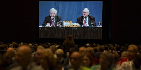 Warren Buffett, chairman and chief executive officer of Berkshire Hathaway Inc., left, and Charlie Munger, vice chairman of Berkshire Hathaway, appear on a screen in an overflow room during the Berkshire Hathaway annual shareholders meeting in Omaha, Nebraska, U.S., on 30 April 2016. (Photo: Daniel Acker / Bloomberg via Getty Images)
