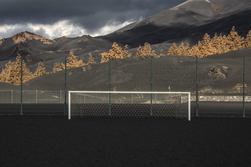 A soccer field in Las Manchas, buried by ash. La Palma, Spain, 21 January 2022. This volcanic eruption on the island of La Palma in the Canary Islands started on 19 September 2021 and lasted for 85 days, destroying thousands of homes and displacing more than 10,000 people in the process. It also covered large areas with ash, which now accumulates everywhere. One of the areas most affected by the ash was the town of Las Manchas, where several meters of ash completely buried many homes. For an assignment I documented the reality of the island and the transformation of its territory one month after the end of the volcano’s eruption. © Cesar Dezfuli, Spain, Shortlist, Professional competition, Landscape, Sony World Photography Awards 2023