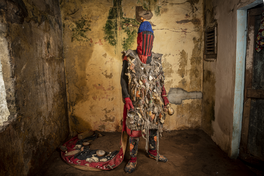 An Egungun in a voodoo convent. He is wearing multiple talismans, which provide him with a strong power. Porto-Novo, Benin. The Egungun association is a secret voodoo society that honours the spirits of their ancestors and perpetuates their memories. These ancestral spirits are believed to be in constant watch over their living relatives; they bless, protect and warn them, but can also punish them depending on whether they remember or neglect them. The spirits can also protect a community against evil spirits, epidemics, witchcraft and evil doers, ensuring their well-being, and may even be invited to come to earth physically. When they do, the Egungun are the receptacles of these spirits, appearing in the streets day or night, leaping, dancing or walking, and uttering loud cries. The spirit is supposed to have returned from the land of the dead to ascertain what is going on, so can be considered a kind of supernatural inquisitor who appears from time to time to inquire into the general domestic conduct of people and punish misdeeds. © Jean-Claude Moschetti, France, Finalist, Professional competition, Portraiture, Sony World Photography Awards 2023 