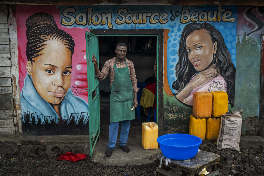 Mohimbo (48) poses in front of his hairdressing salon in Goma, Democratic Republic of Congo, 26 November 2022. On the N2 highway leading north out of Goma in the Democratic Republic of Congo, colourful hair salon storefronts hide interiors full of customers. The customers are mostly women who are ready to spend their entire day getting the perfect hairstyle, whether it’s butterfly or tribal braids, or curly hair twists. Yet while most of the work is performed by women, it seems that the salons are owned by men, some as young as 20 years old. At a time of tension and economic uncertainty, the bold names and brightly coloured storefronts bring a sense of normalcy to residents who have contended with conflict and natural disasters for decades. The Salon Mixte, the Clinique de Beauté, the Just Love salon and the Salon King are all open for business and here to stay. Despite fighting between M23 rebels and FARDC government forces north of Goma, life goes on for residents of the lakeside town. © Jerome Delay, France, Shortlist, Professional competition, Portraiture, Sony World Photography Awards 2023