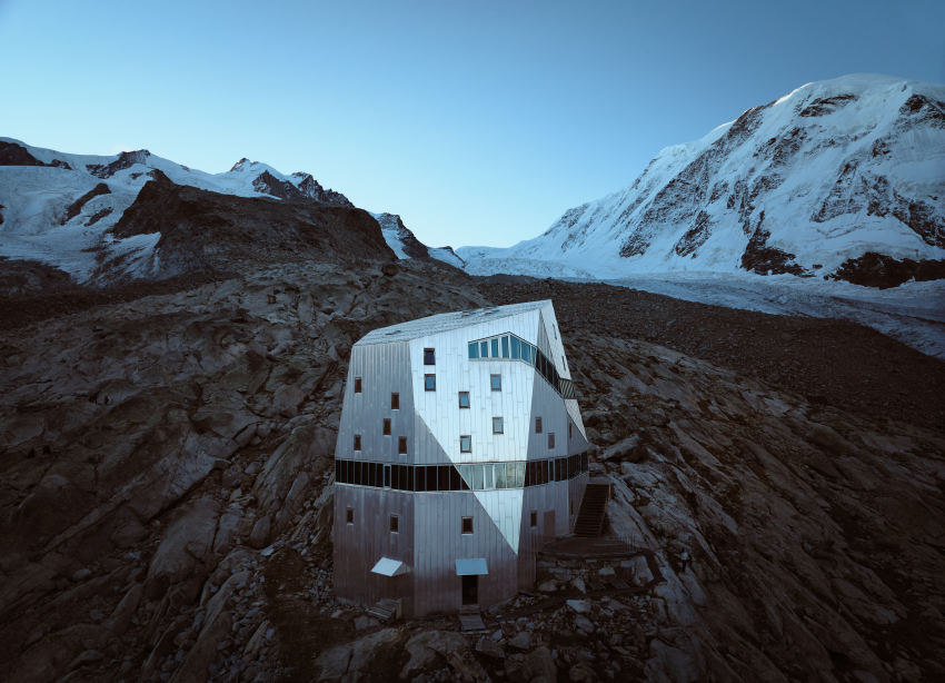 'Monte Rosa Hut - Blue Hour'. I took this photograph as part of my Modern Alpine Architecture series. After crossing a glacier and hiking for many hours we arrived at the mountain hut and stayed there for the night. Early in the morning, before sunrise, I started my drone to capture the first light of the new day falling on this beautiful piece of architecture. © Albrecht Voss, Germany, Shortlist, Open Competition, Architecture, 2023 Sony World Photography Awards