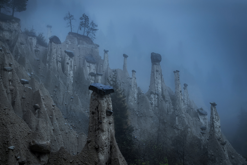 'Earth Pyramids'. Taken in Percha, Italy. These earth pyramids were formed millions of years ago in the Dolomite mountains. On this particular morning they were in low clouds, which adds to the atmosphere. © Robert Bilos, Croatia, Shortlist, Open Competition, Landscape, 2023 Sony World Photography Awards