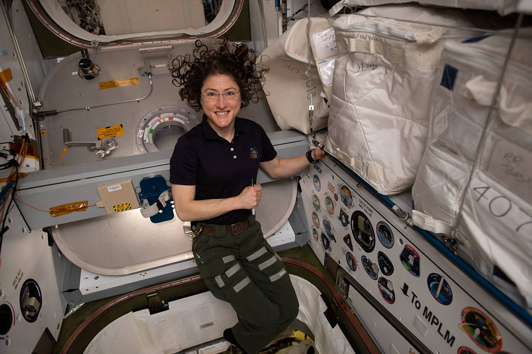 NASA astronaut Christina Koch poses for a portrait inside of the vestibule between the SpaceX Dragon cargo craft and the Harmony module. The hatch to Dragon was later closed and the resupply ship detached from Harmony before it was released from the grips of the Canadarm2 robotic arm. Dragon spent nearly a month attached to the International Space Station. Image: NASA