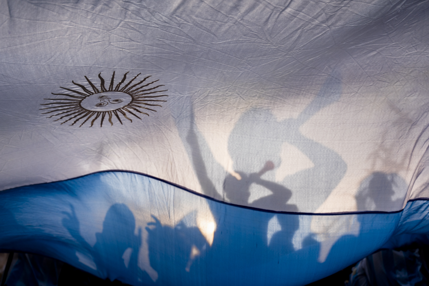 'White and Blue'. Argentina fans in Dhaka, Bangladesh, celebrate with a huge Argentine flag ahead of their match in the 2022 FIFA World Cup. Bangladesh has a large number of fans of the Argentina football team. © Rizwan Hasan, Bangladesh, Shortlist, Open Competition, Street Photography, 2023 Sony World Photography Awards