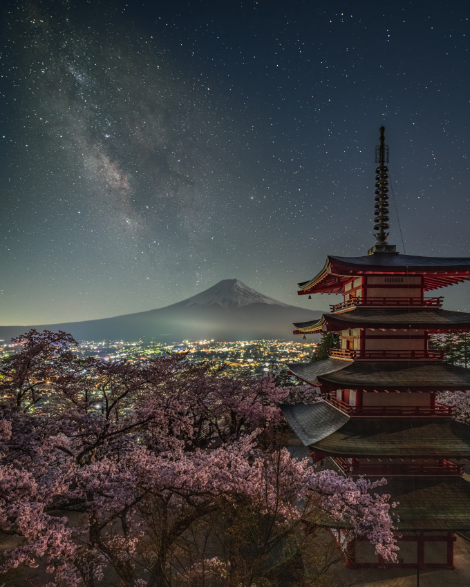 'Milky Way from Chureito Pagoda. On the night of a new moon in April, with the cherry blossoms in full bloom, the Milky Way rose above Mount Fuji. It is rare that full bloom cherry blossoms, a new moon and clear skies coincide – this was the first time in three years that I was able to photograph this scene. © Yukihito Ono, Japan, Shortlist, Open Competition, Travel, 2023 Sony World Photography Awards
