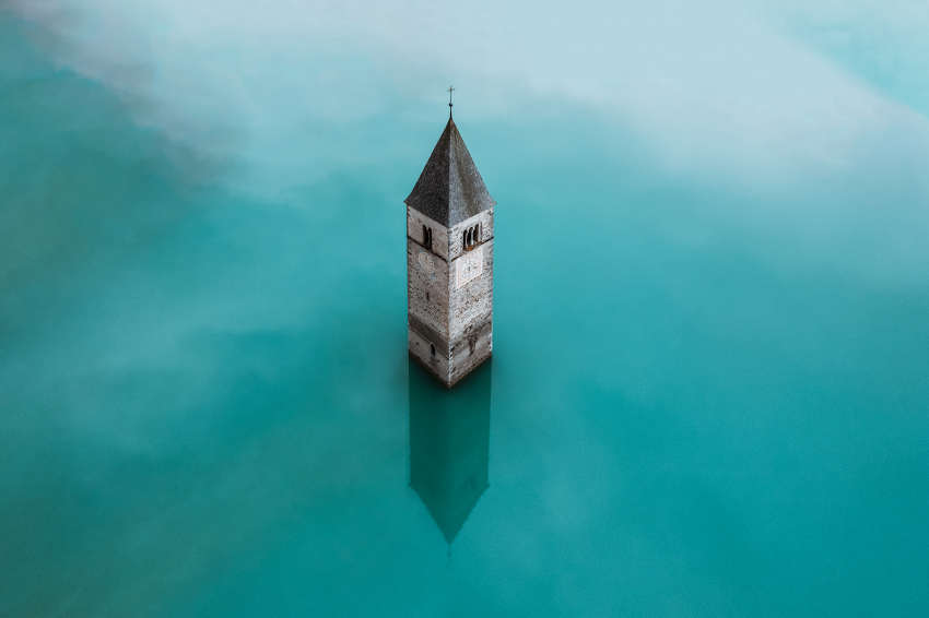 'Sunken Church Tower'. In 1950 the Italian village of Curon was flooded to create the artificial basin of Lake Resia, to power a hydroelectric dam. Today, the only visible remnant of the village is the 14th-century church tower jutting from the water. © Paweł Jagiełło, Poland, Shortlist, Open Competition, Travel, 2023 Sony World Photography Awards
