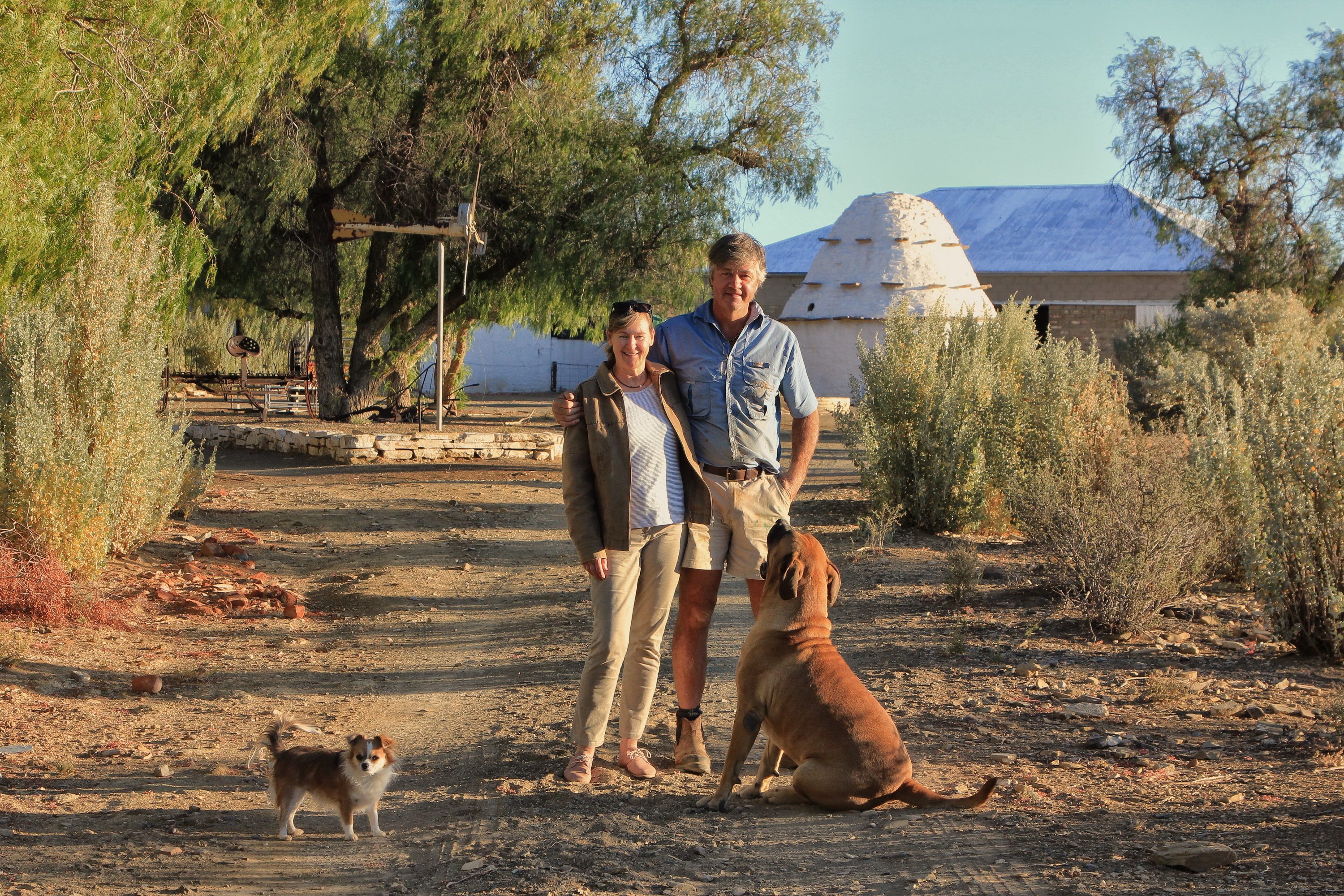 Francy and Peter, with dogs Lila and Jeff, in front of the farmstead and corbelled house. Image: Chris Marais