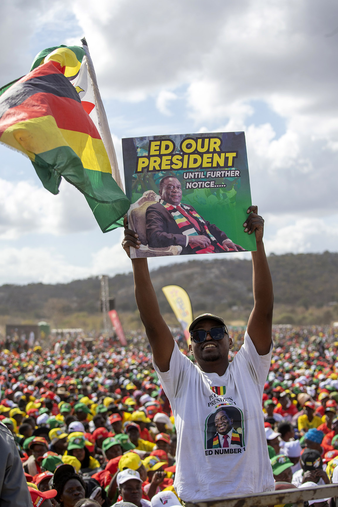 A Zimbabwe man holds a Zanu-PF election poster