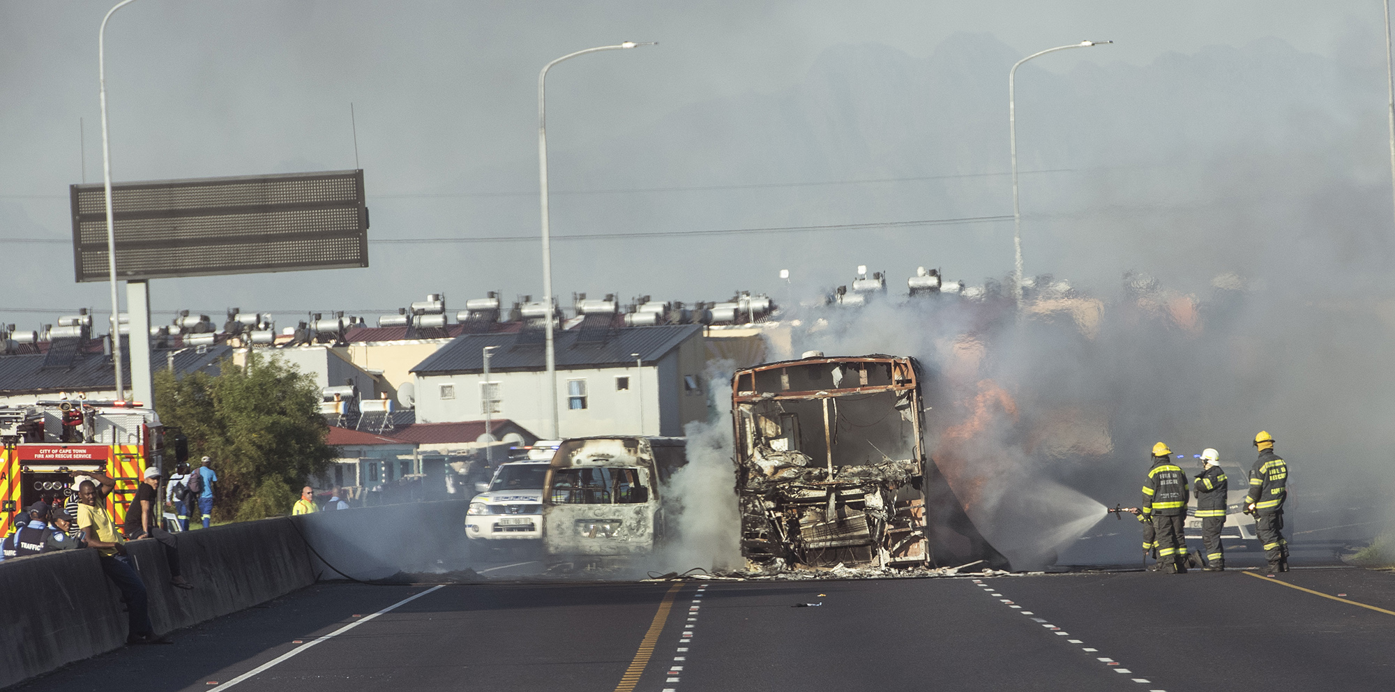 Fireman douse a burning bus during the Cape Town taxi strike