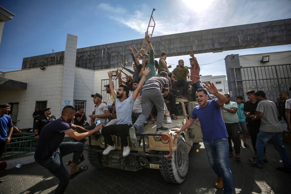 Palestinians ride an Israeli military jeep