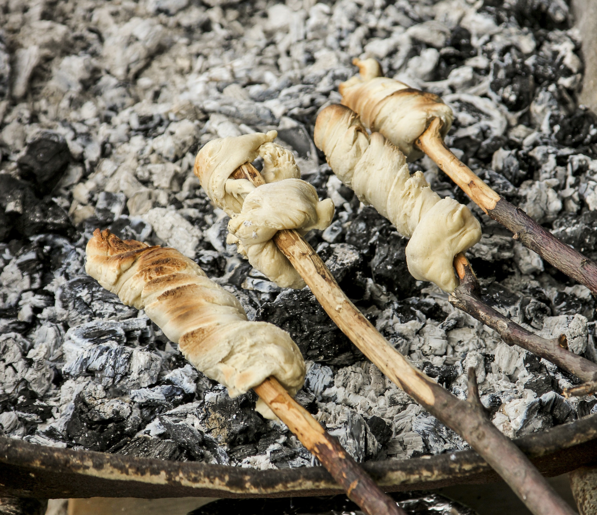 One of the great pleasures for kids at a braai – stokkiesbrood, or dough wound around a stick and slowly cooked over a fire. Image: Chris Marais