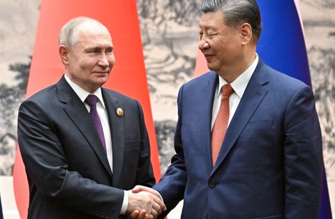 Russian President Vladimir Putin shakes hands with Chinese President Xi Jinping