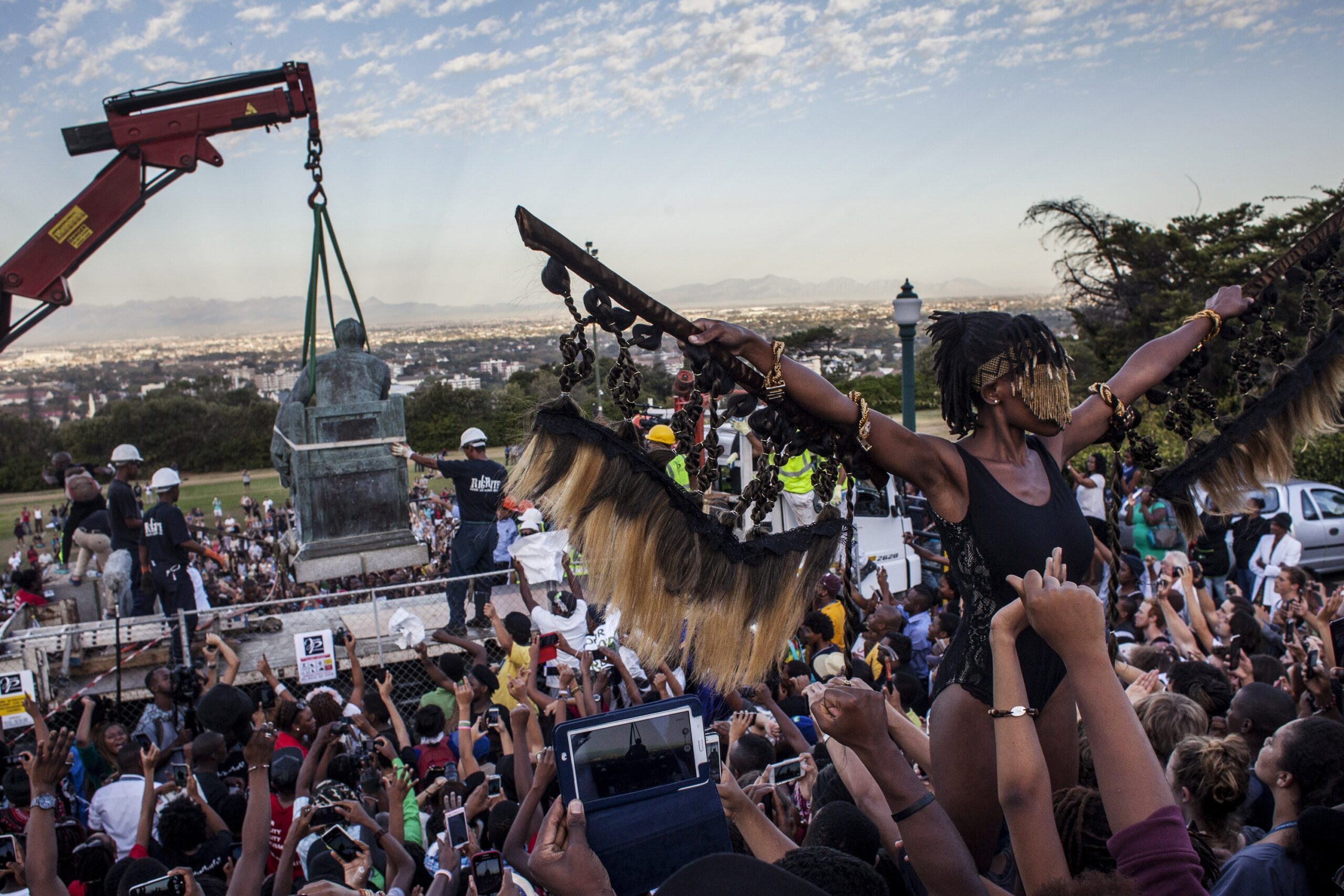 Students cheer as the Cecil Rhodes statue is being removed from the University of Cape Town on April 9, 2015 in Cape Town, South Africa. The statue of British colonialist Cecil John Rhodes was removed from the University of Cape Town as a result of a month long protest by students citing the statue "great symbolic power" which glorified someone "who exploited black labour and stole land from indigenous people". (Photo by Charlie Shoemaker/Getty Images)